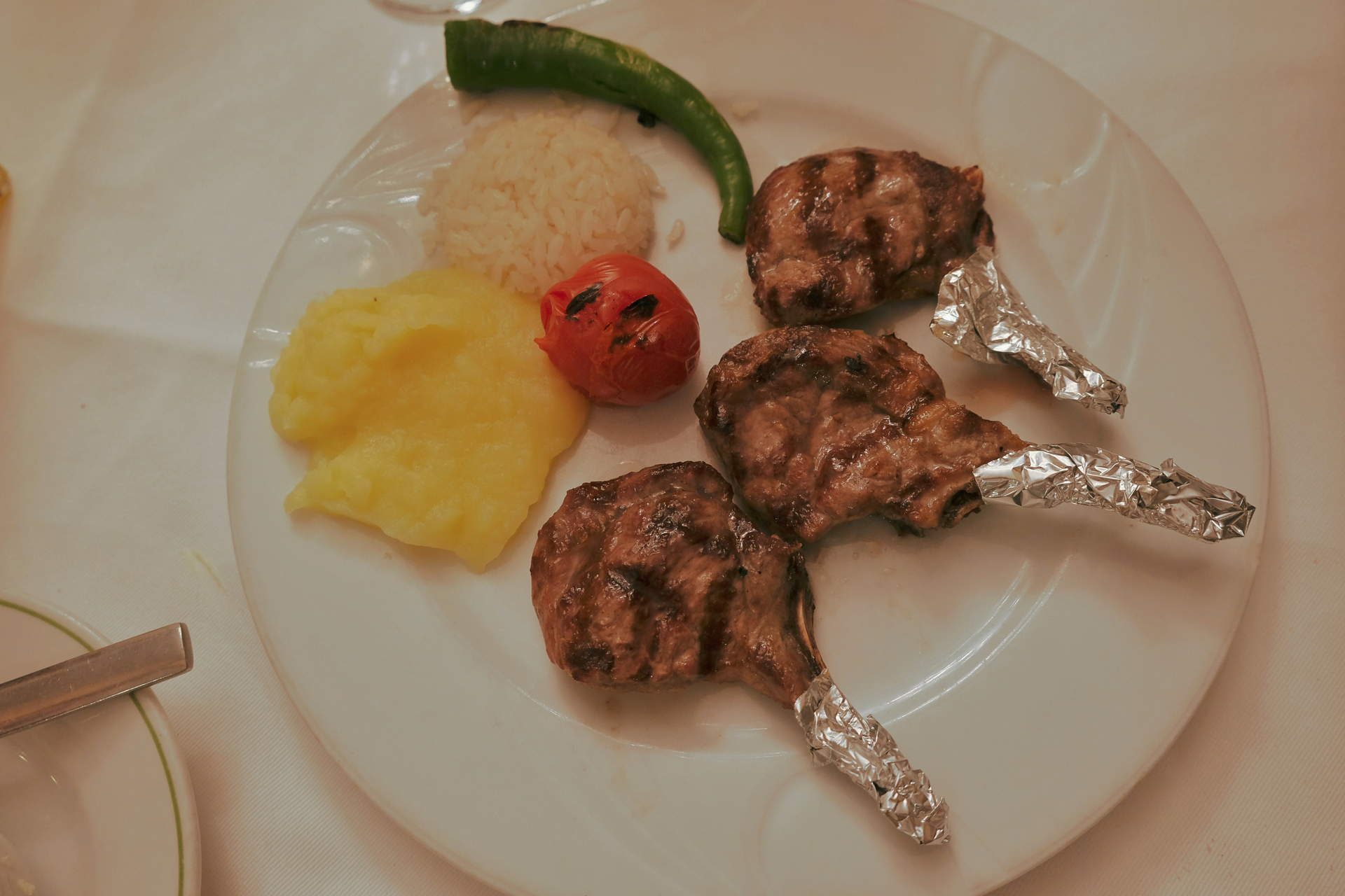 Overhead flat-lay of all ingredients for Afghan Tandoori Lamb Chops with Citrus Yogurt Drizzle laid out on a kitchen surface.