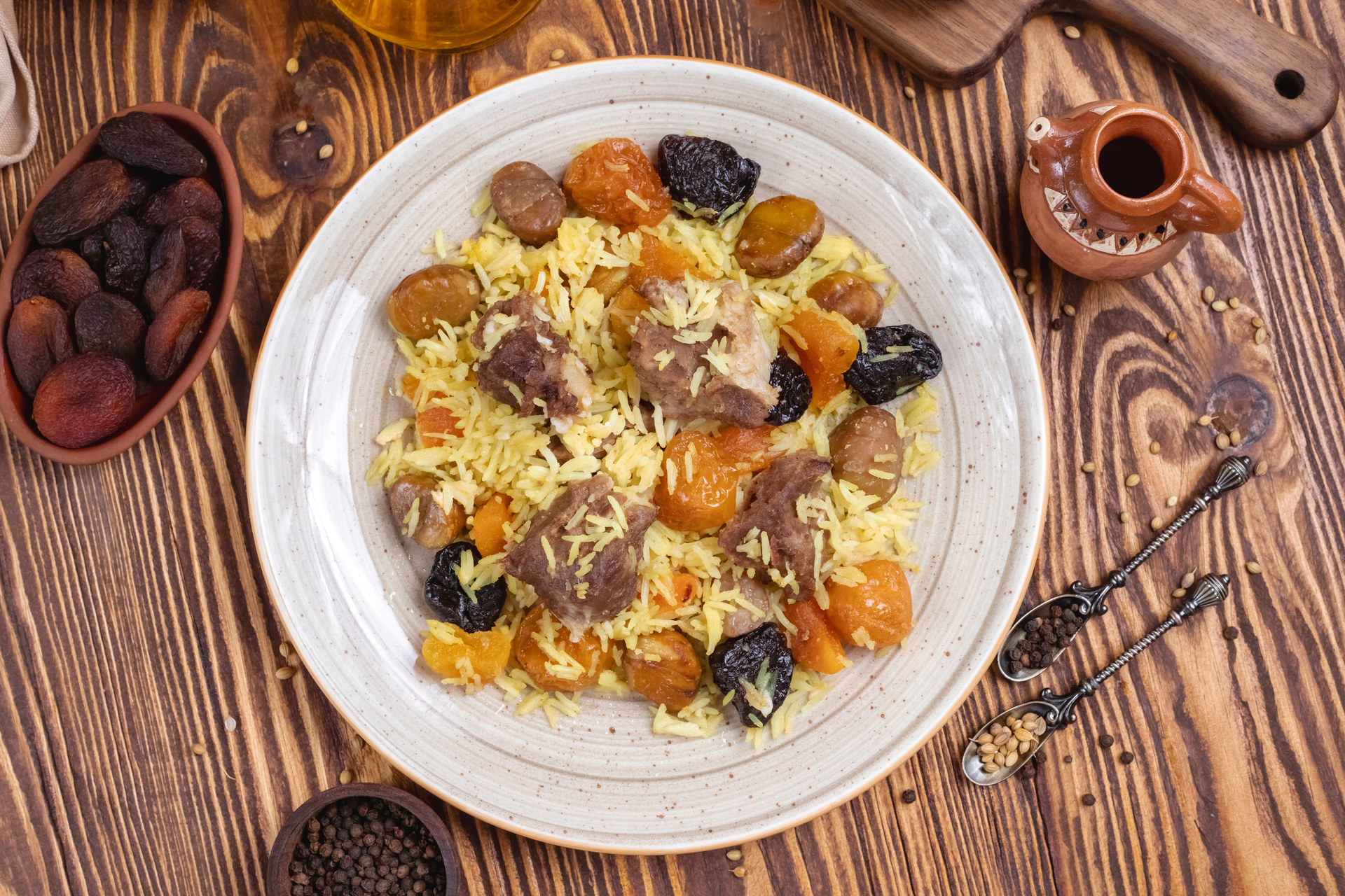 Overhead flat-lay of all ingredients for Afghani Kabuli Pulao with Tender Lamb and Golden Raisins laid out on a kitchen surface.