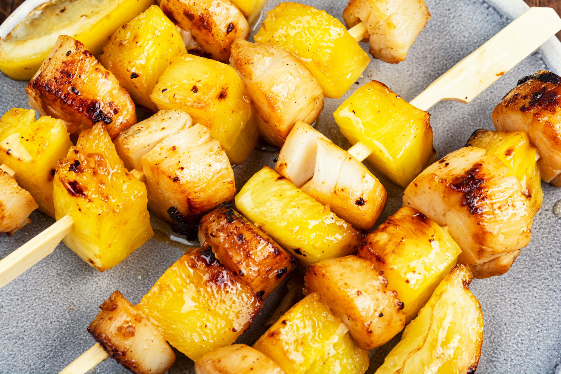Overhead flat-lay of all ingredients for African Peanut Butter and Honey Chicken Skewers with Fresh Pineapple Slices laid out on a kitchen surface.