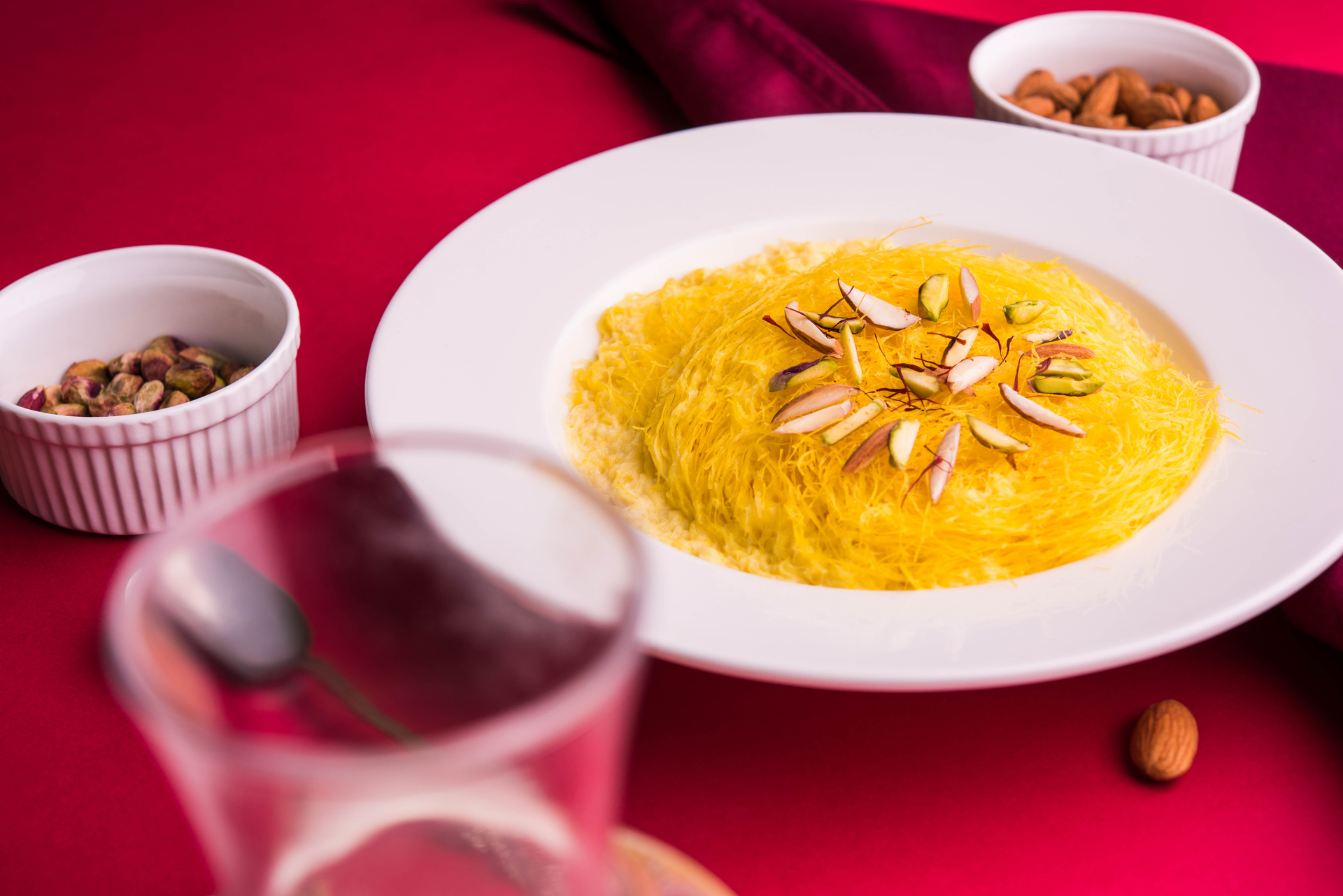 Overhead flat-lay of all ingredients for Almond-Infused Persian Shirin Polo with Orange Peel and Saffron laid out on a kitchen surface.