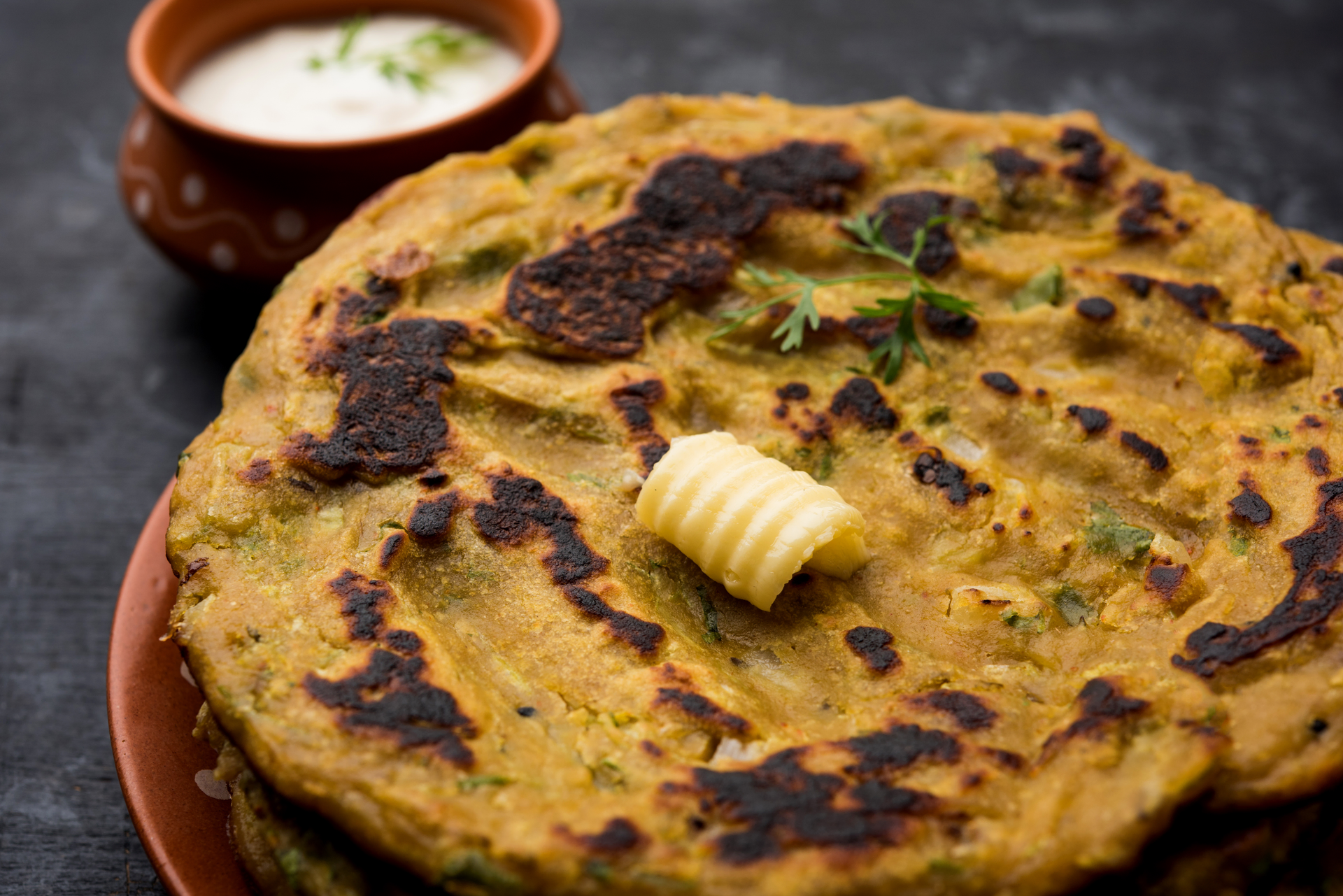 Overhead flat-lay of all ingredients for Aloo Paratha with Spiced Potato Filling and Ghee laid out on a kitchen surface.