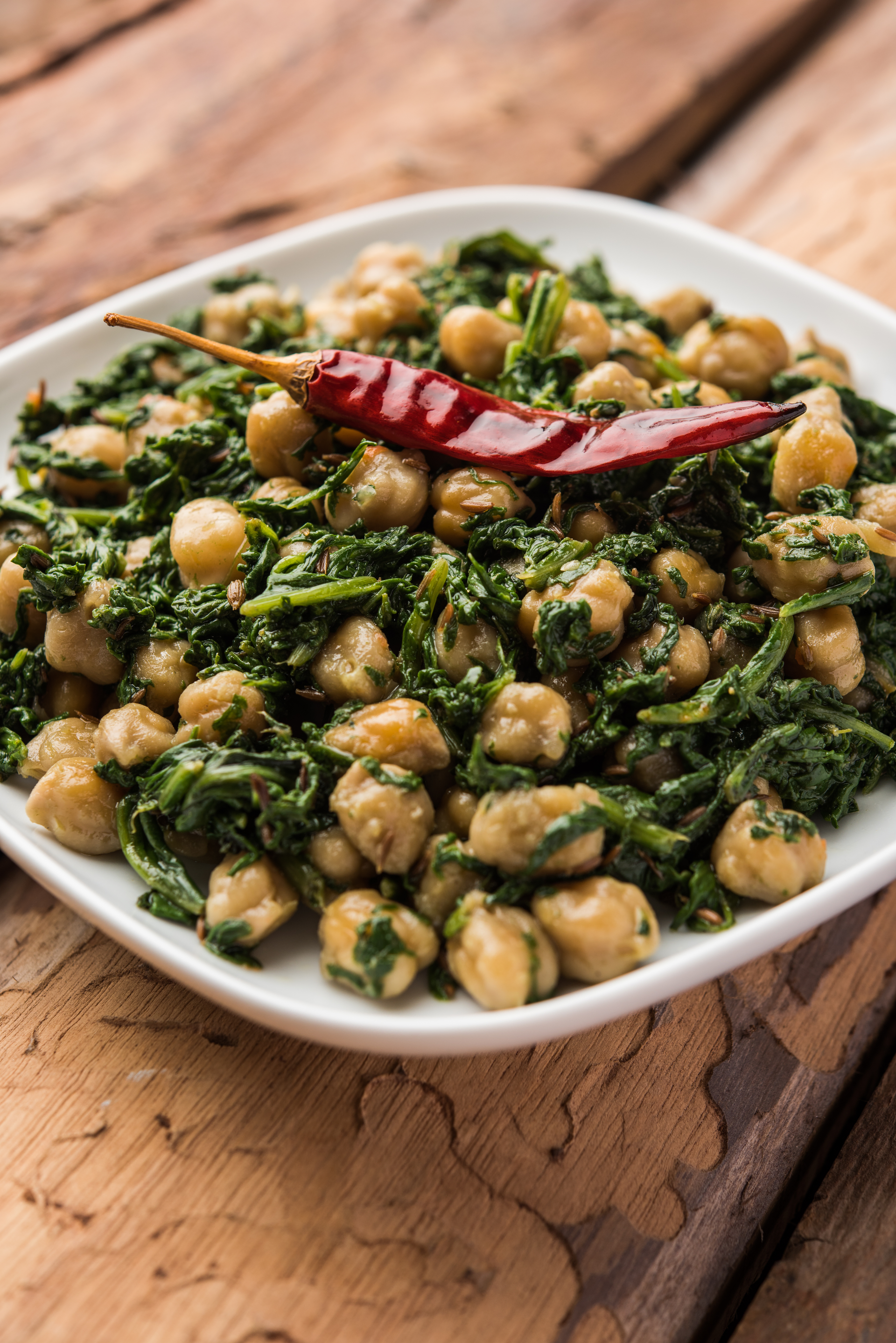 Overhead flat-lay of all ingredients for Andalusian Chickpea Spinach Stew with Paprika laid out on a kitchen surface.