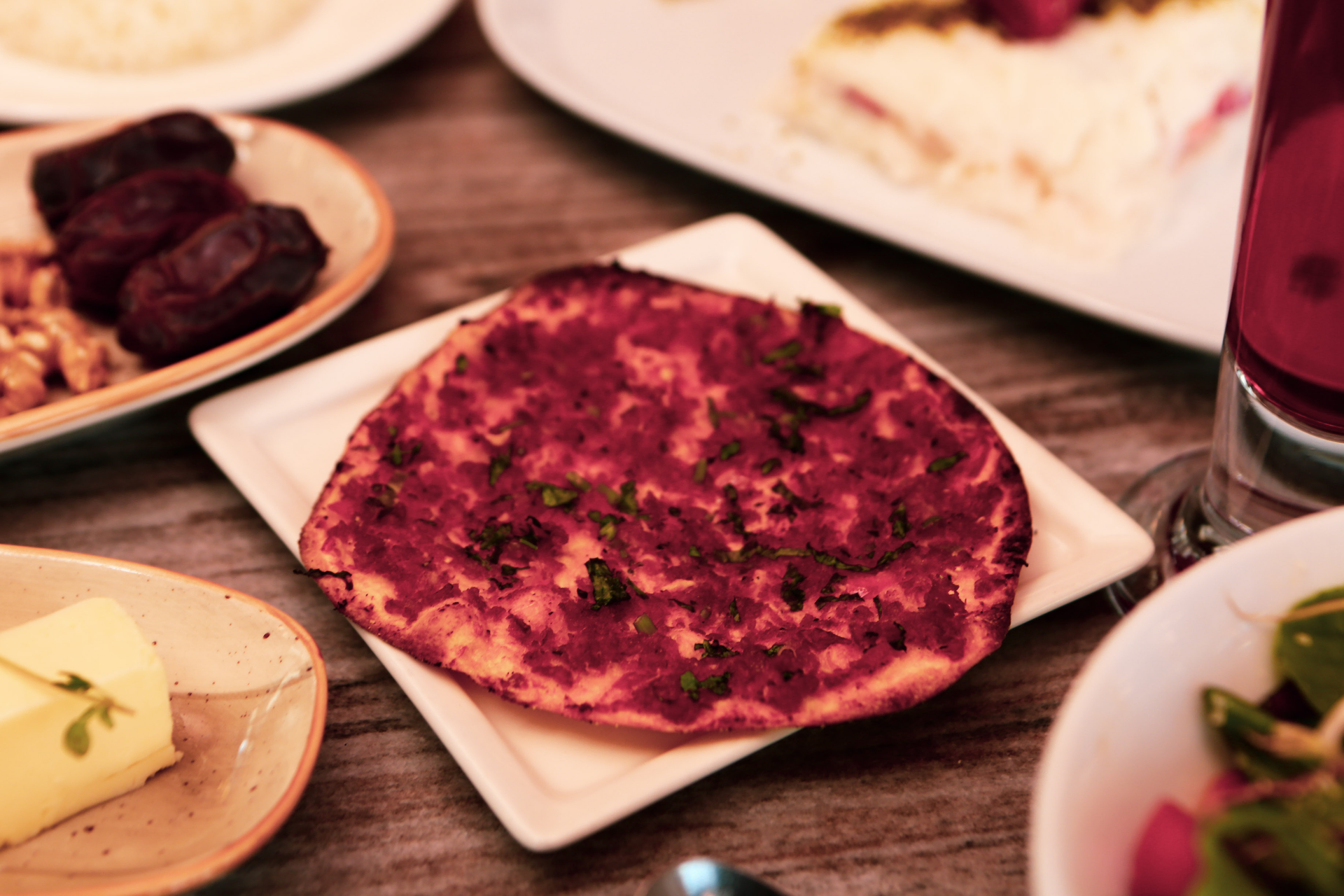 Overhead flat-lay of all ingredients for Armenian Walnut and Pomegranate Salsa with Khachapuri laid out on a kitchen surface.
