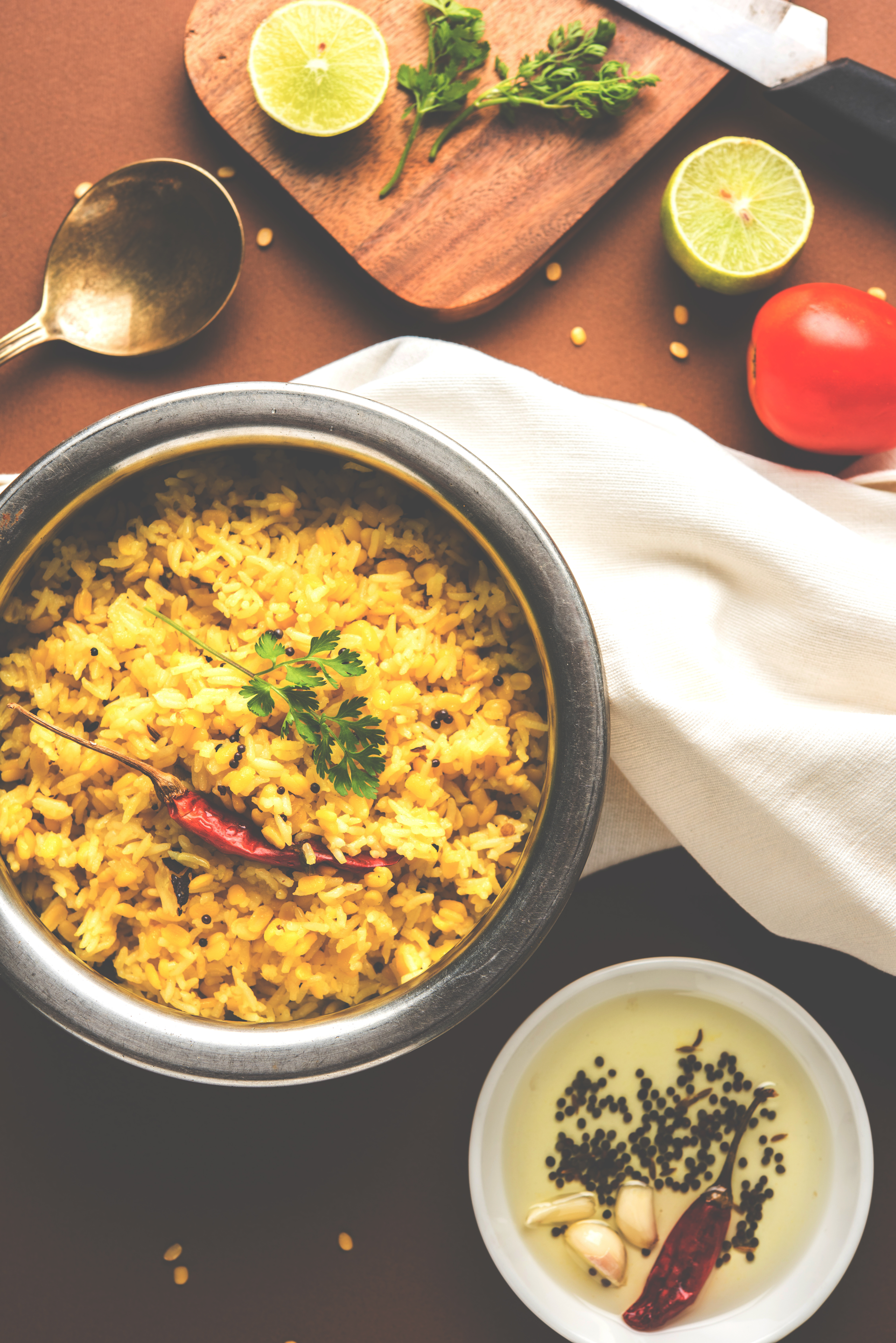 Overhead flat-lay of all ingredients for Aromatic Bangladeshi Bhuna Khichuri laid out on a kitchen surface.