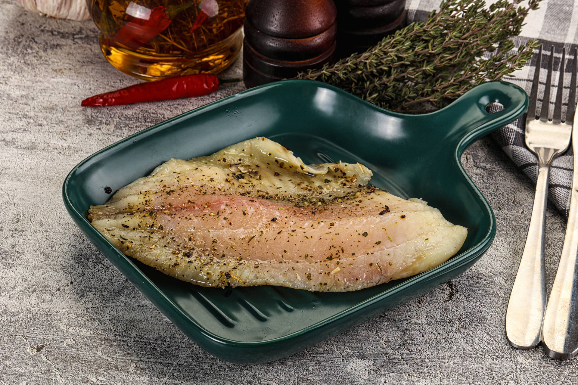 Overhead flat-lay of all ingredients for Aromatic Basque Cod al Pil-Pil laid out on a kitchen surface.