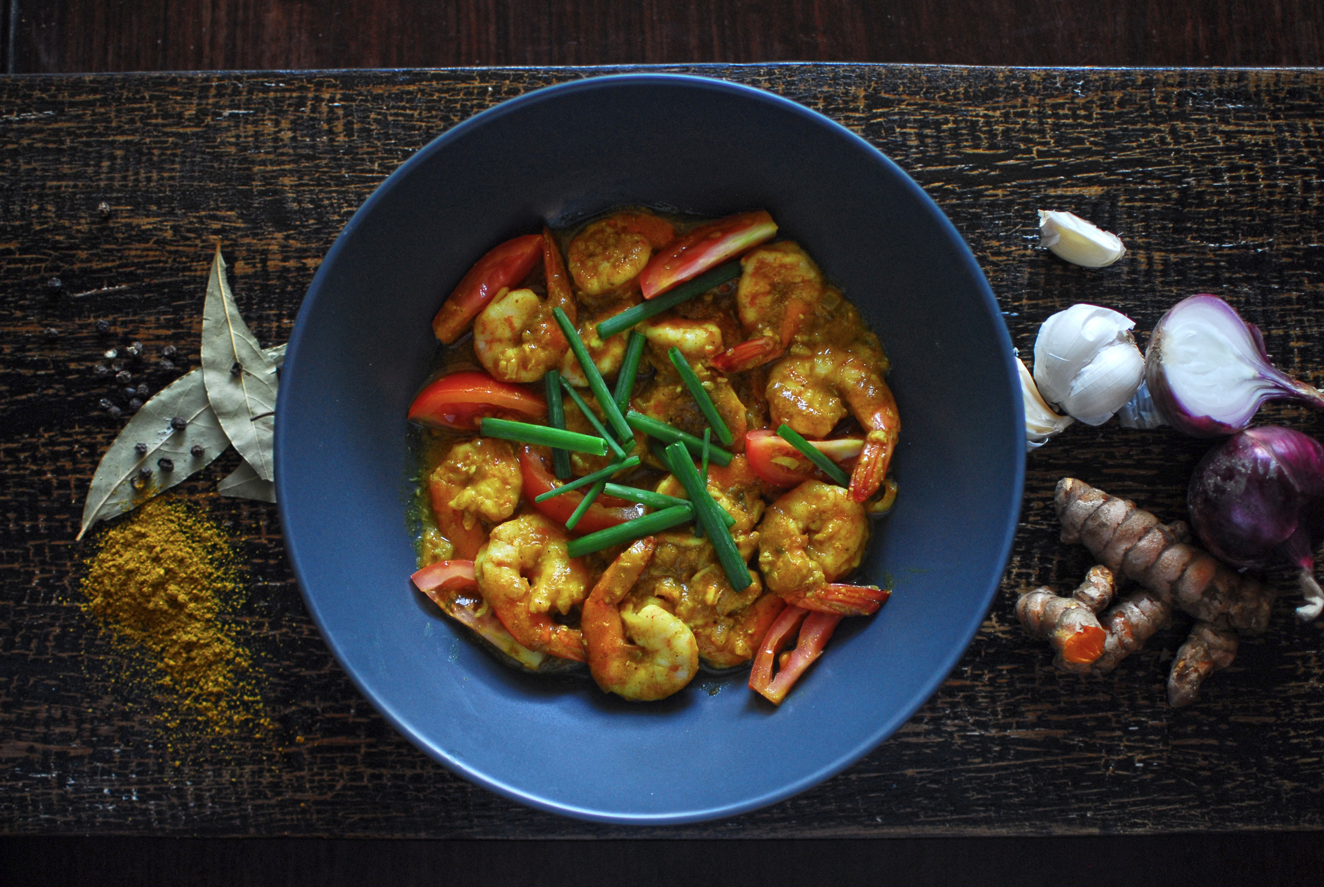 Overhead flat-lay of all ingredients for Aromatic Burmese Tamarind Prawn Curry with Fresh Coriander laid out on a kitchen surface.