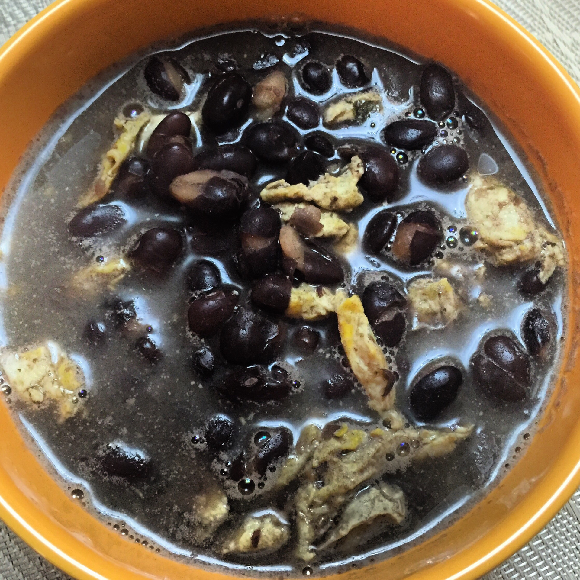 Overhead flat-lay of all ingredients for Aromatic Cuban Black Bean Soup with Orange Mojo laid out on a kitchen surface.