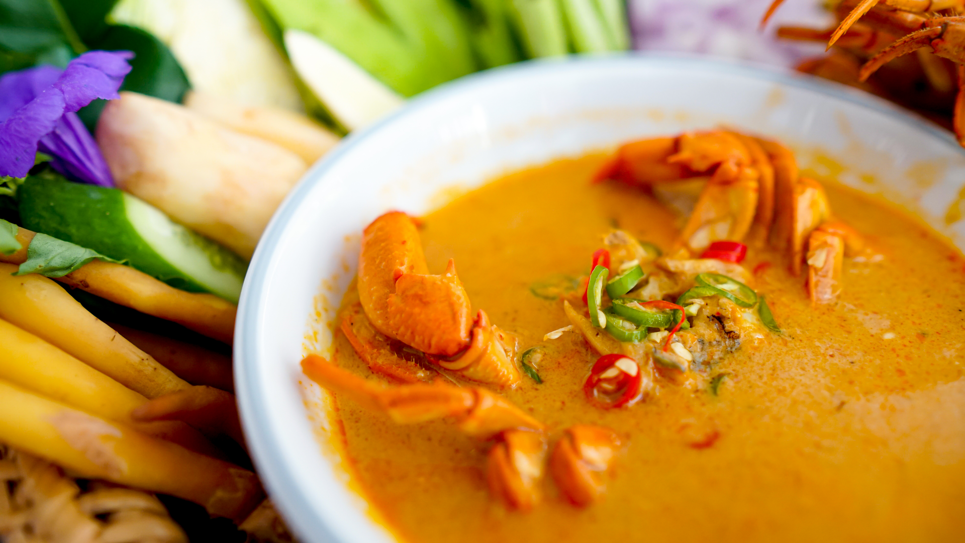 Overhead flat-lay of all ingredients for Aromatic Malaysian Curry Laksa with Prawns and Coconut Milk laid out on a kitchen surface.