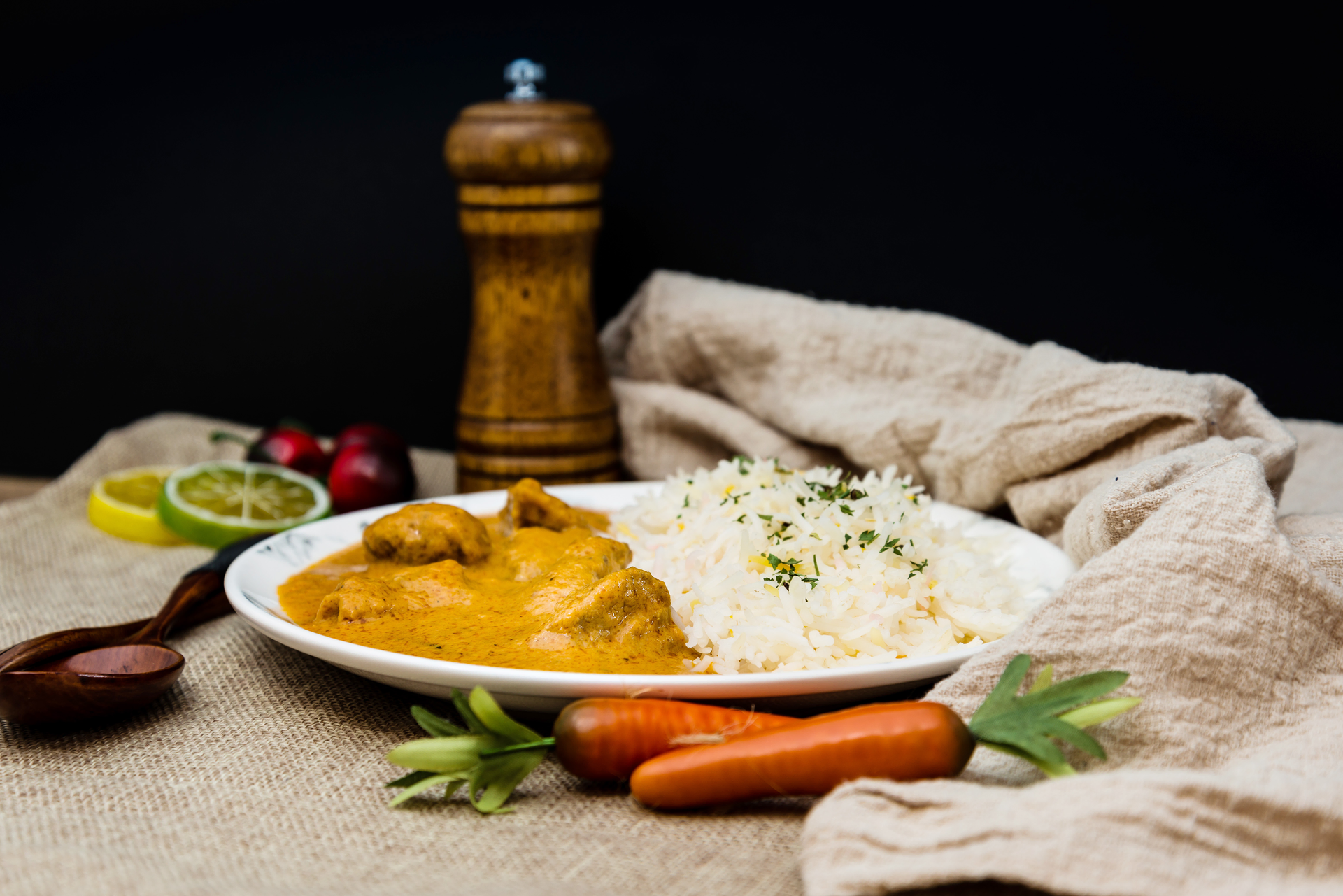 Overhead flat-lay of all ingredients for Aromatic Mauritian Chicken Kalia with Saffron Rice laid out on a kitchen surface.
