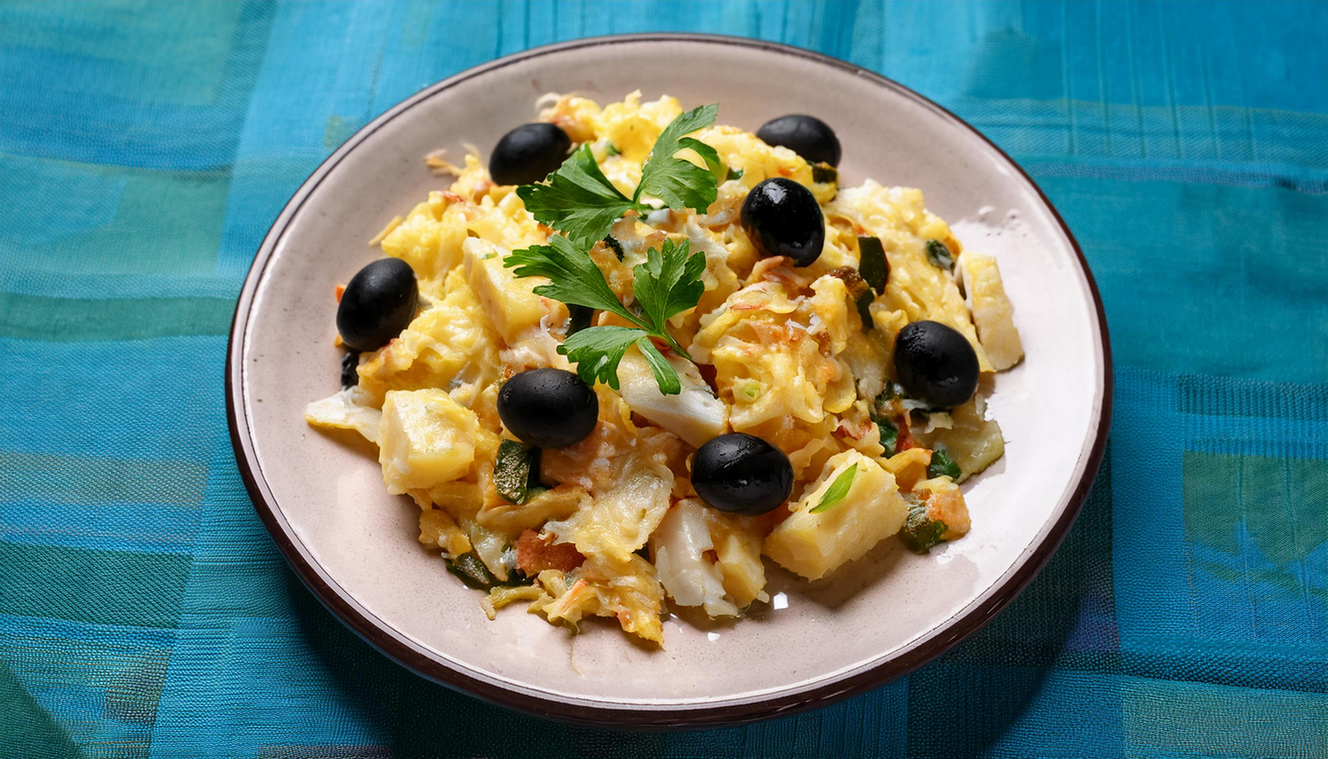 Aromatic Portuguese Bacalhau à Brás with Olive Garnish — Main Course served and photographed from above