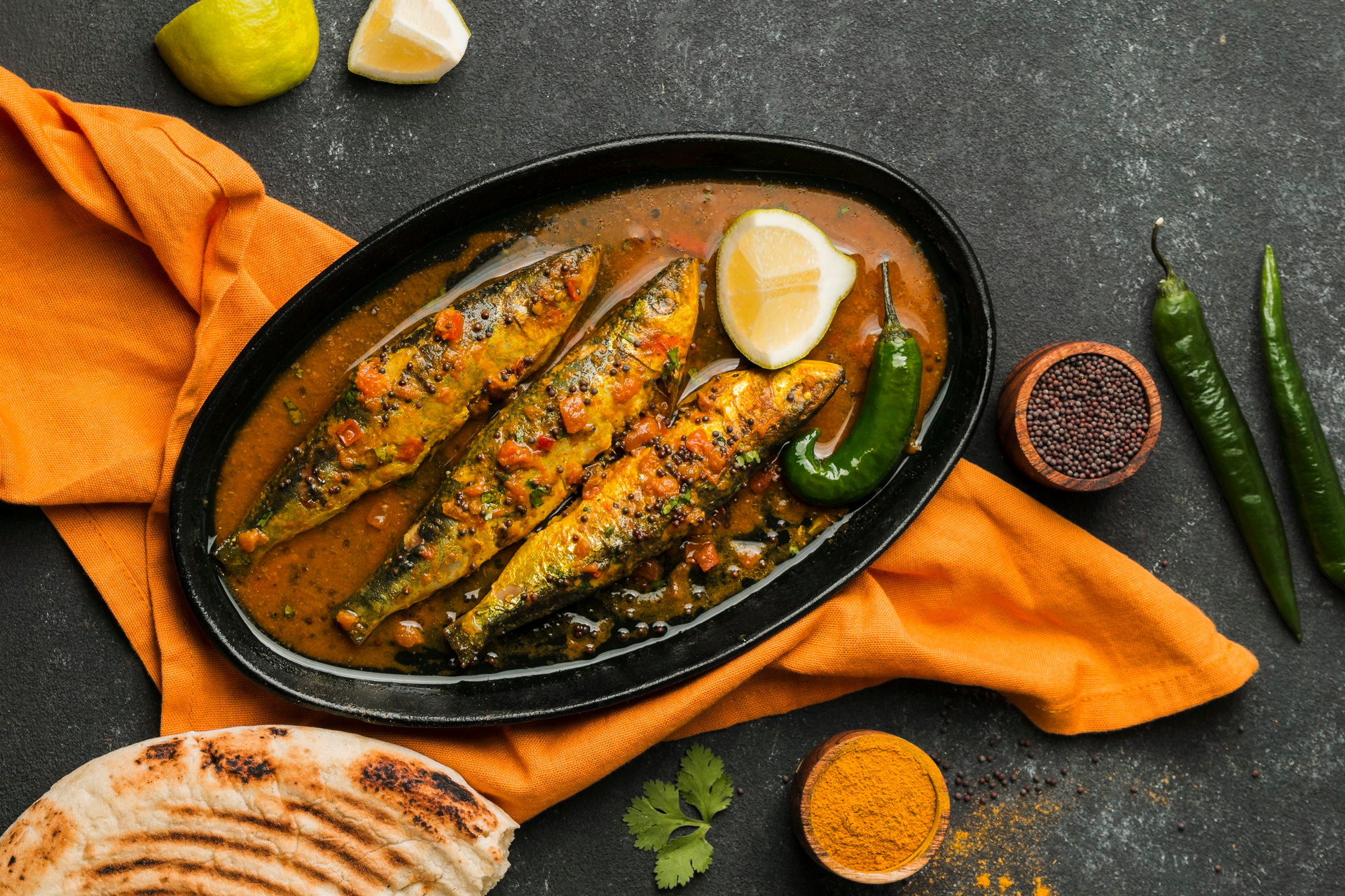 Overhead flat-lay of all ingredients for Aromatic Sri Lankan Fish Curry laid out on a kitchen surface.