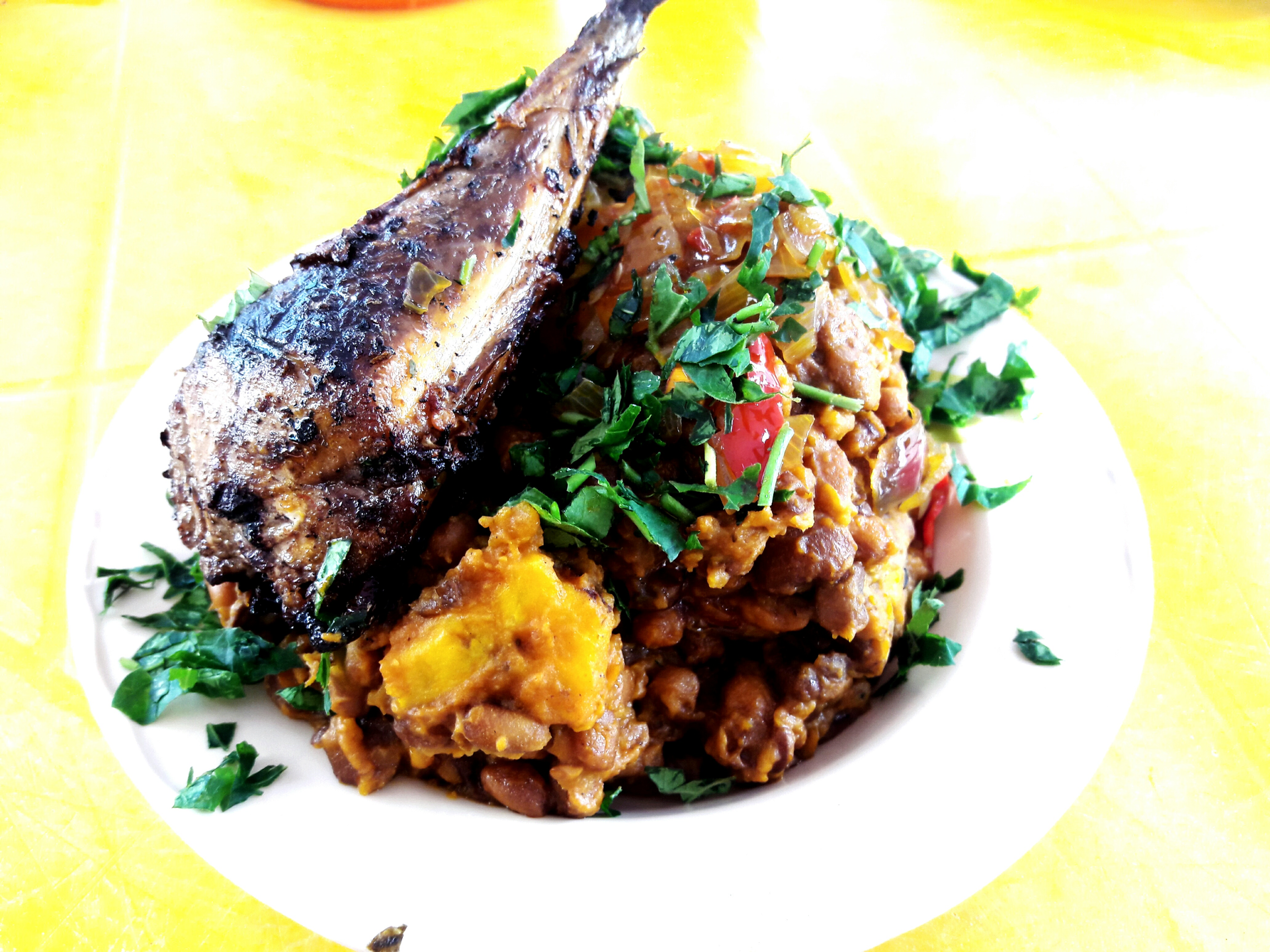 Overhead flat-lay of all ingredients for Aromatic Tanzanian Samaki wa Kupaka laid out on a kitchen surface.