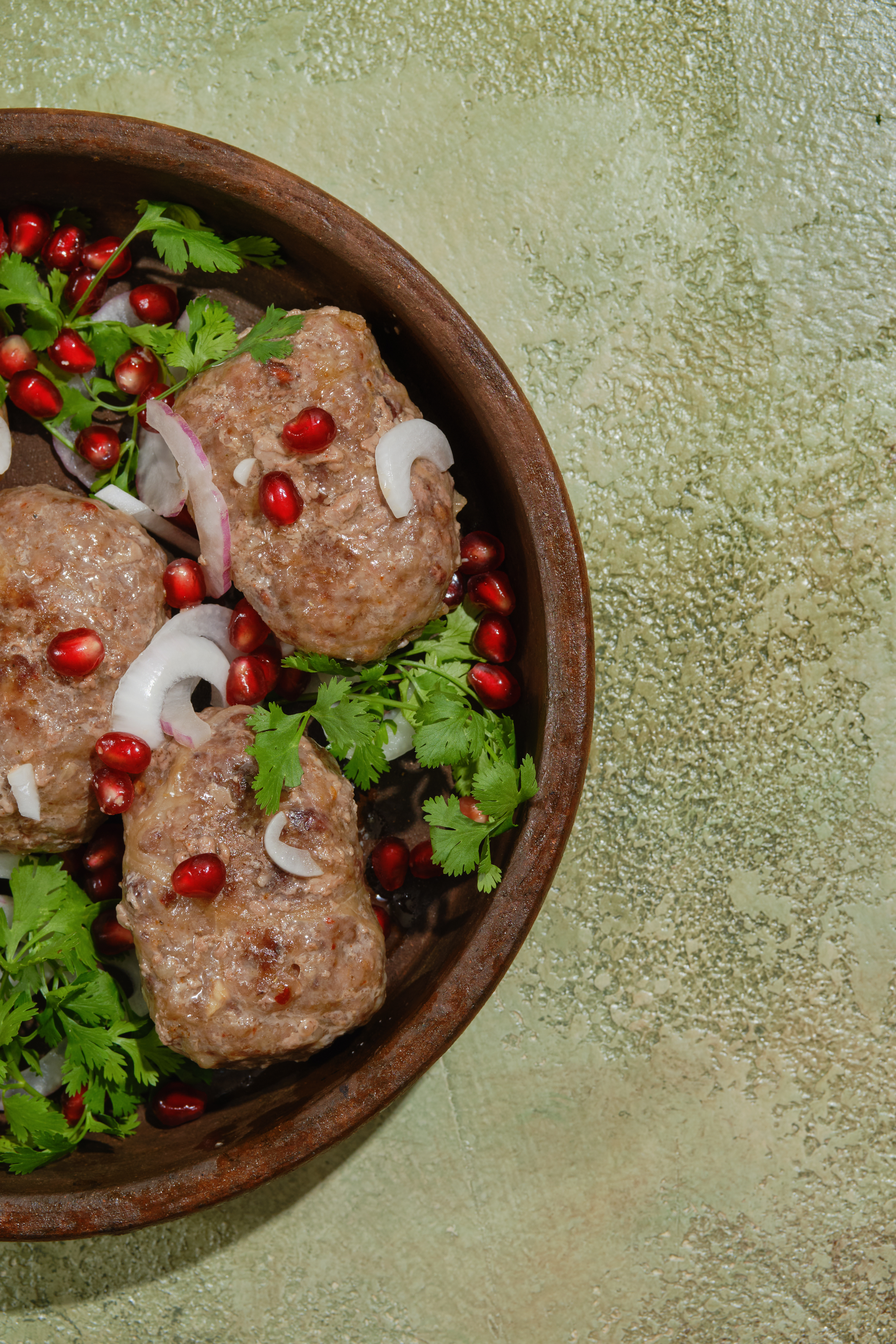 Overhead flat-lay of all ingredients for Aromatic Turkish Köfte with Sumac Onions laid out on a kitchen surface.