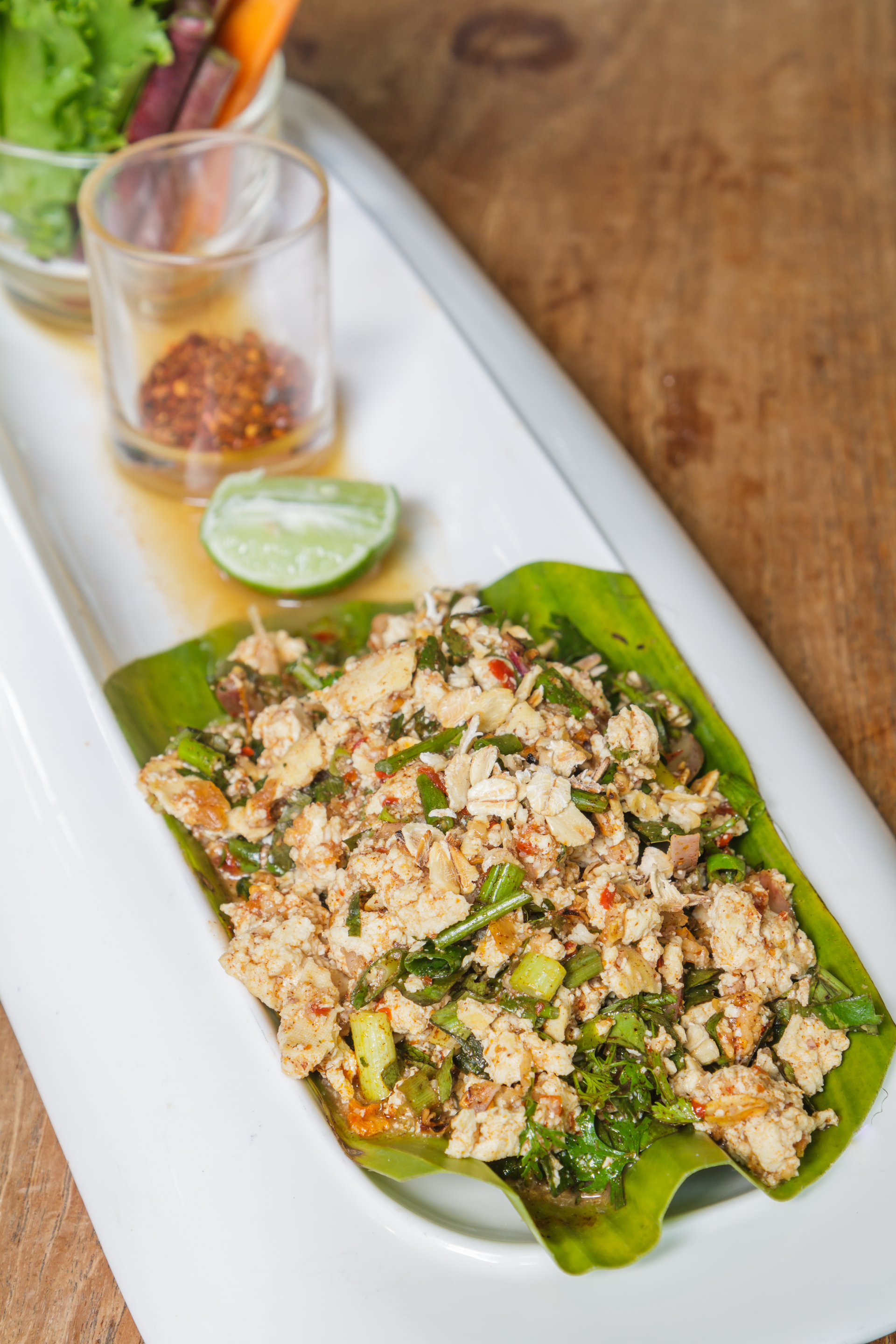 Overhead flat-lay of all ingredients for Thai larb recipe: authentic spicy ground meat salad laid out on a kitchen surface.