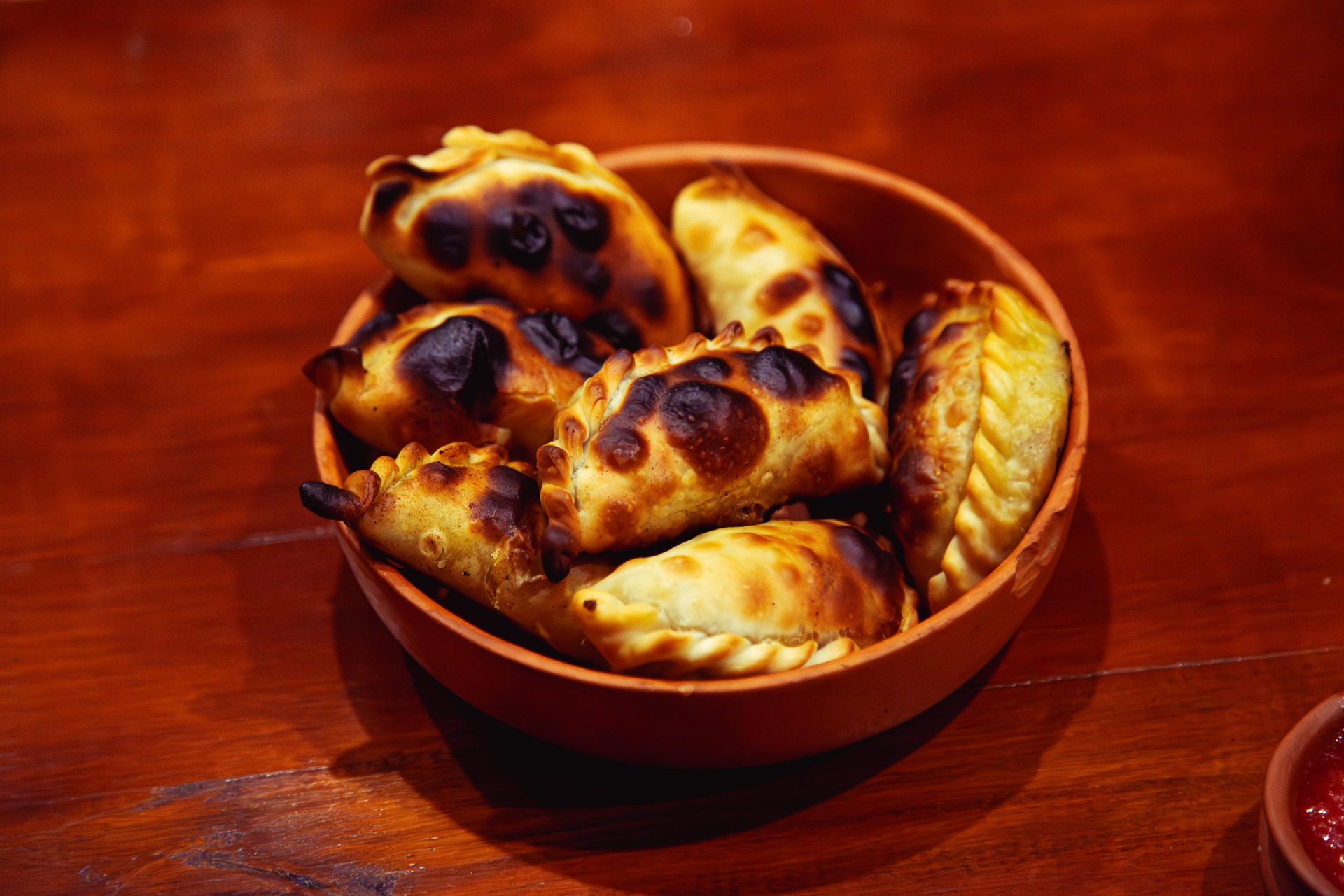 Overhead flat-lay of all ingredients for Baked Plantain Empanadas with Black Bean and Chili Filling laid out on a kitchen surface.