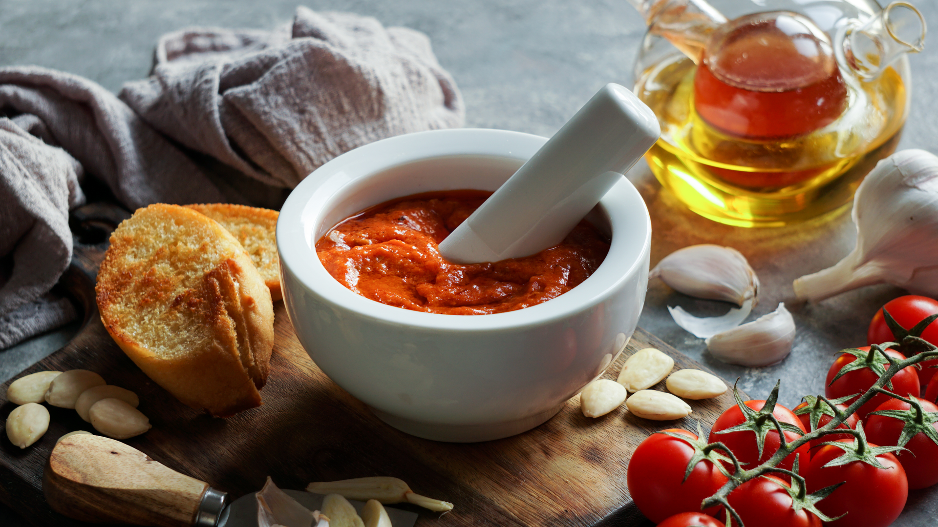 Overhead flat-lay of all ingredients for Balkan Ajvar with Roasted Red Peppers and Garlic laid out on a kitchen surface.