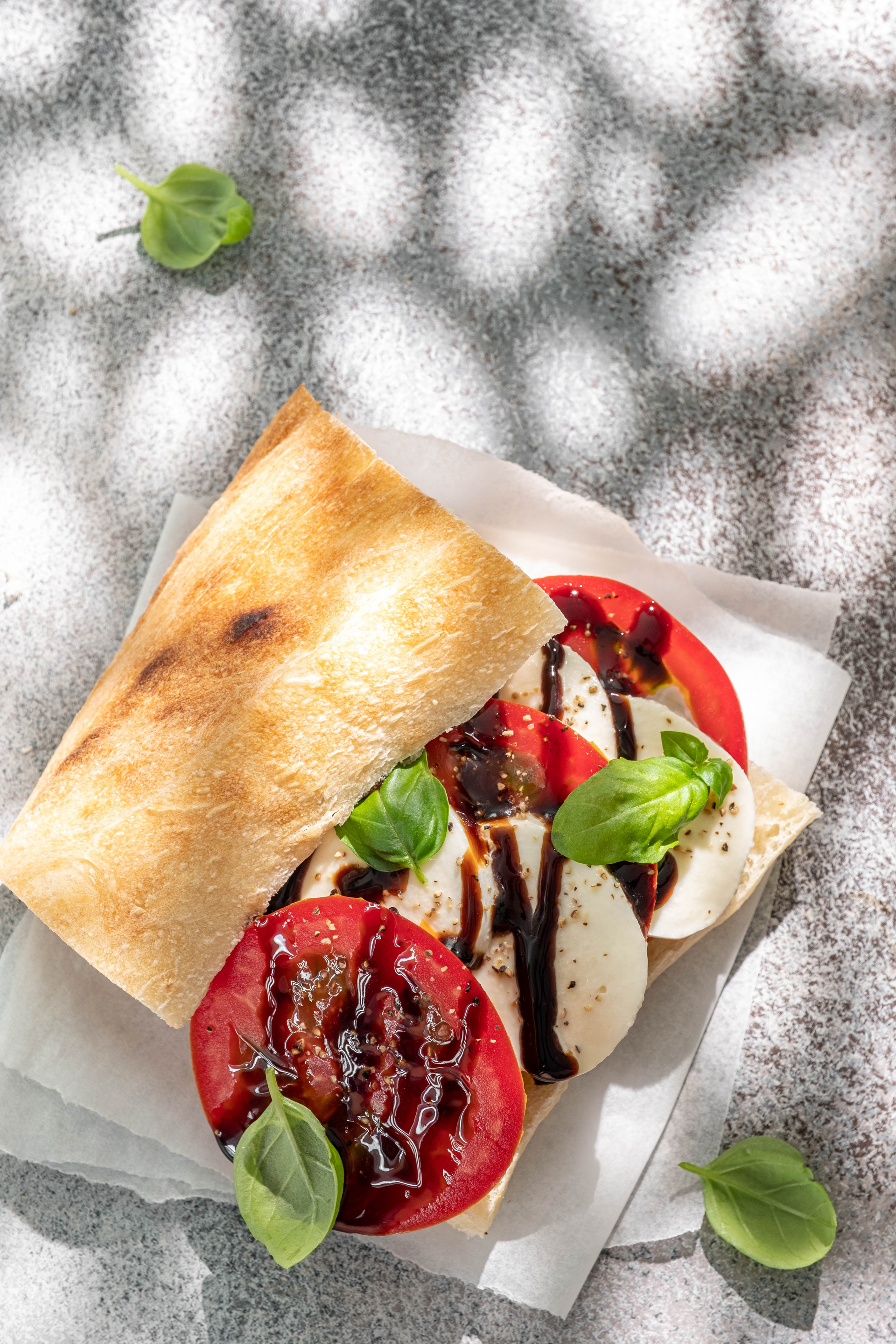 Overhead flat-lay of all ingredients for Balsamic-Glazed Italian Caprese Tart laid out on a kitchen surface.