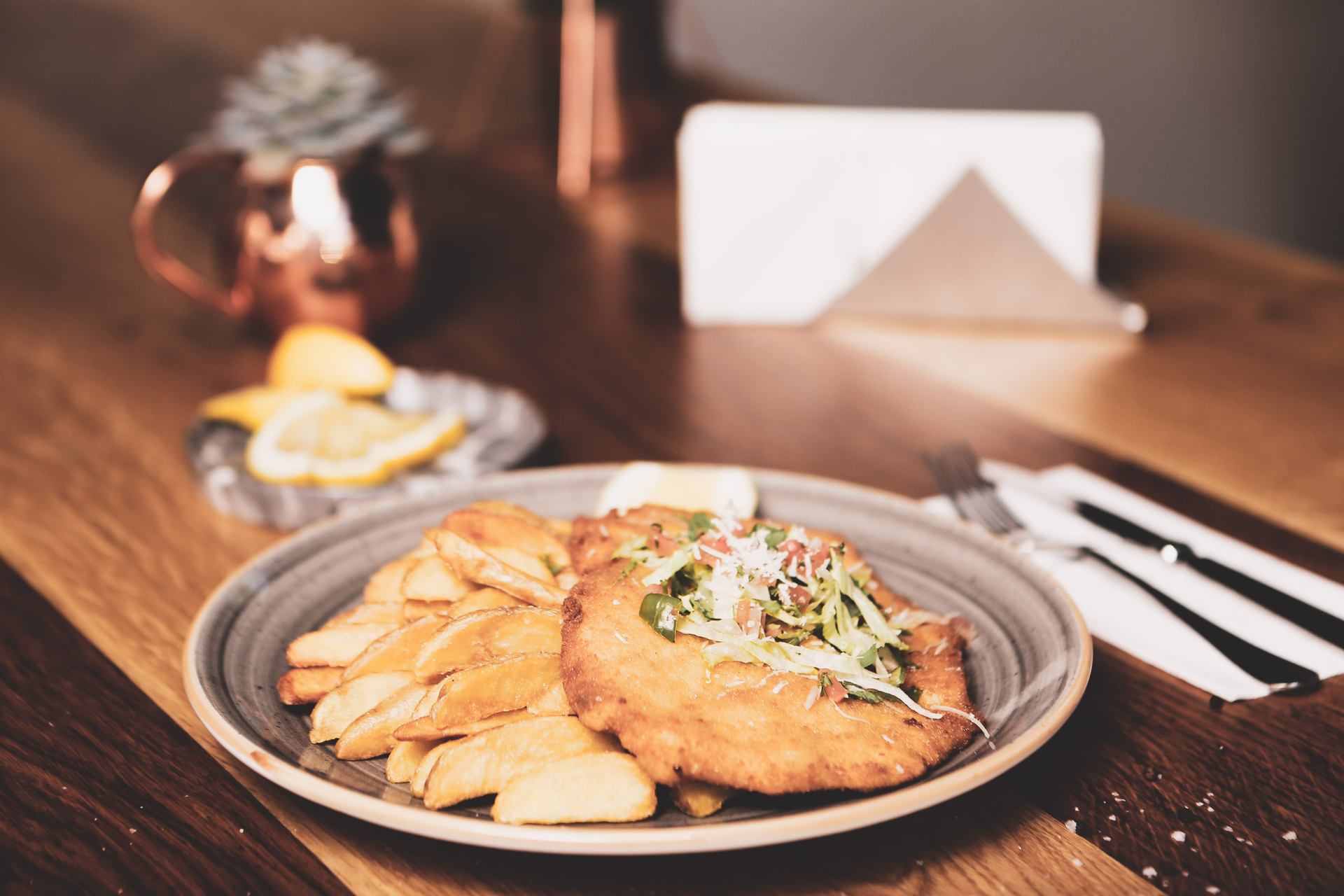 Overhead flat-lay of all ingredients for Bavarian Pretzel-Crusted Pork Schnitzel with Mustard Aioli laid out on a kitchen surface.
