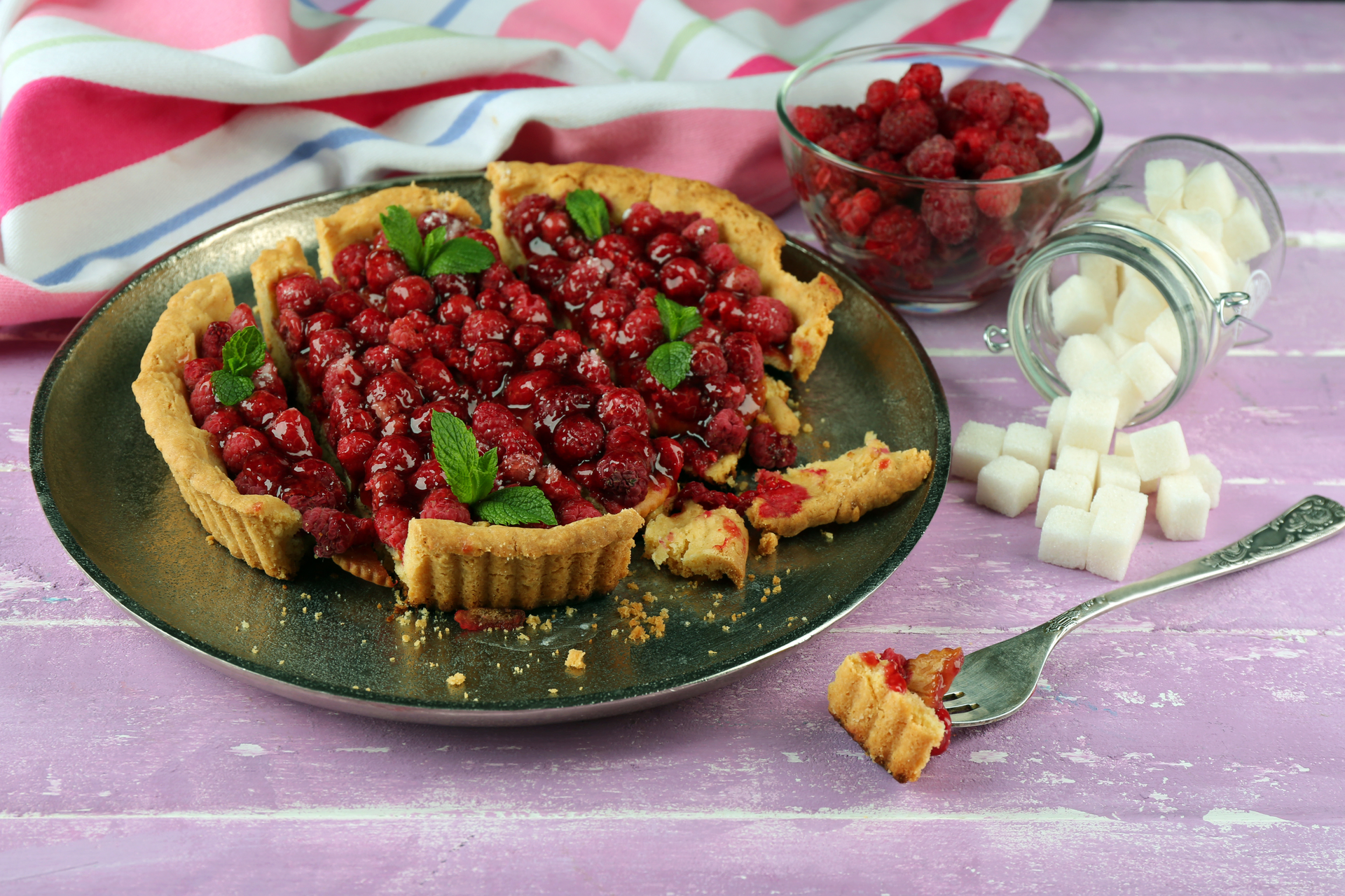 Overhead flat-lay of all ingredients for Bavarian Raspberry Linzer Torte with Hazelnut Crust laid out on a kitchen surface.