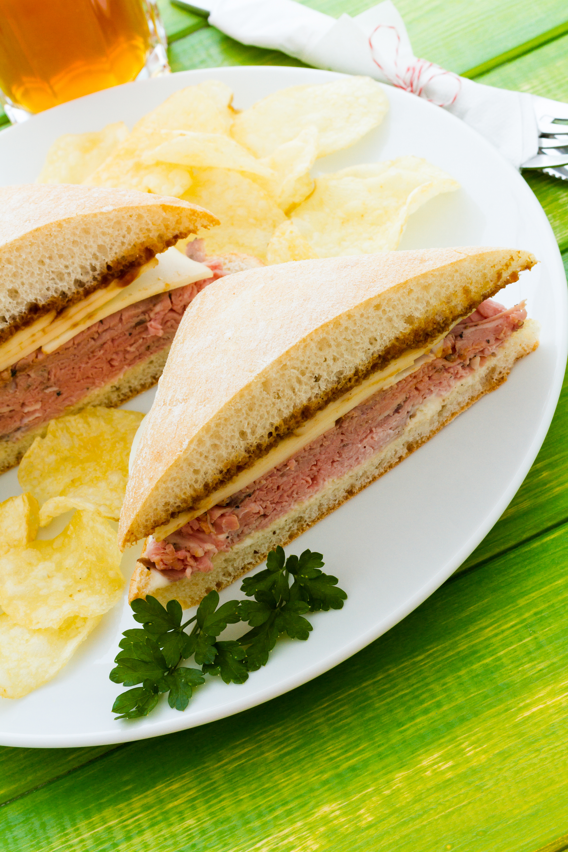 Overhead flat-lay of all ingredients for Brazilian Cheese Bread Sandwich with Mortadella and Herb Aioli laid out on a kitchen surface.