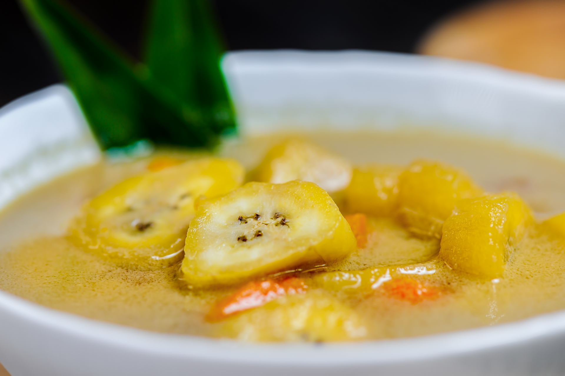 Overhead flat-lay of all ingredients for Brazilian Moqueca de Banana with Cashew Milk laid out on a kitchen surface.