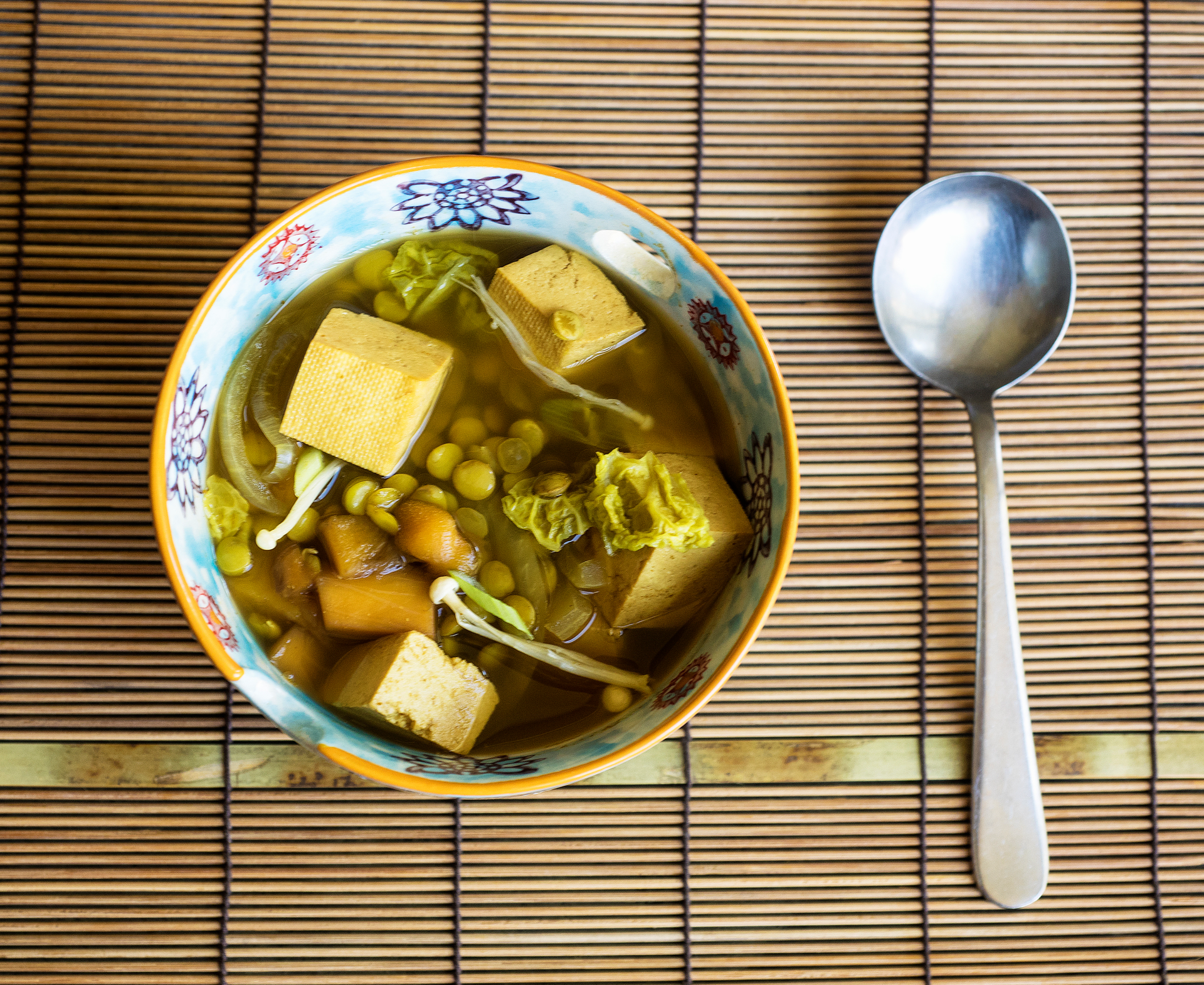 Overhead flat-lay of all ingredients for Burmese Fermented Tea Leaf Tofu with Pickled Ginger laid out on a kitchen surface.