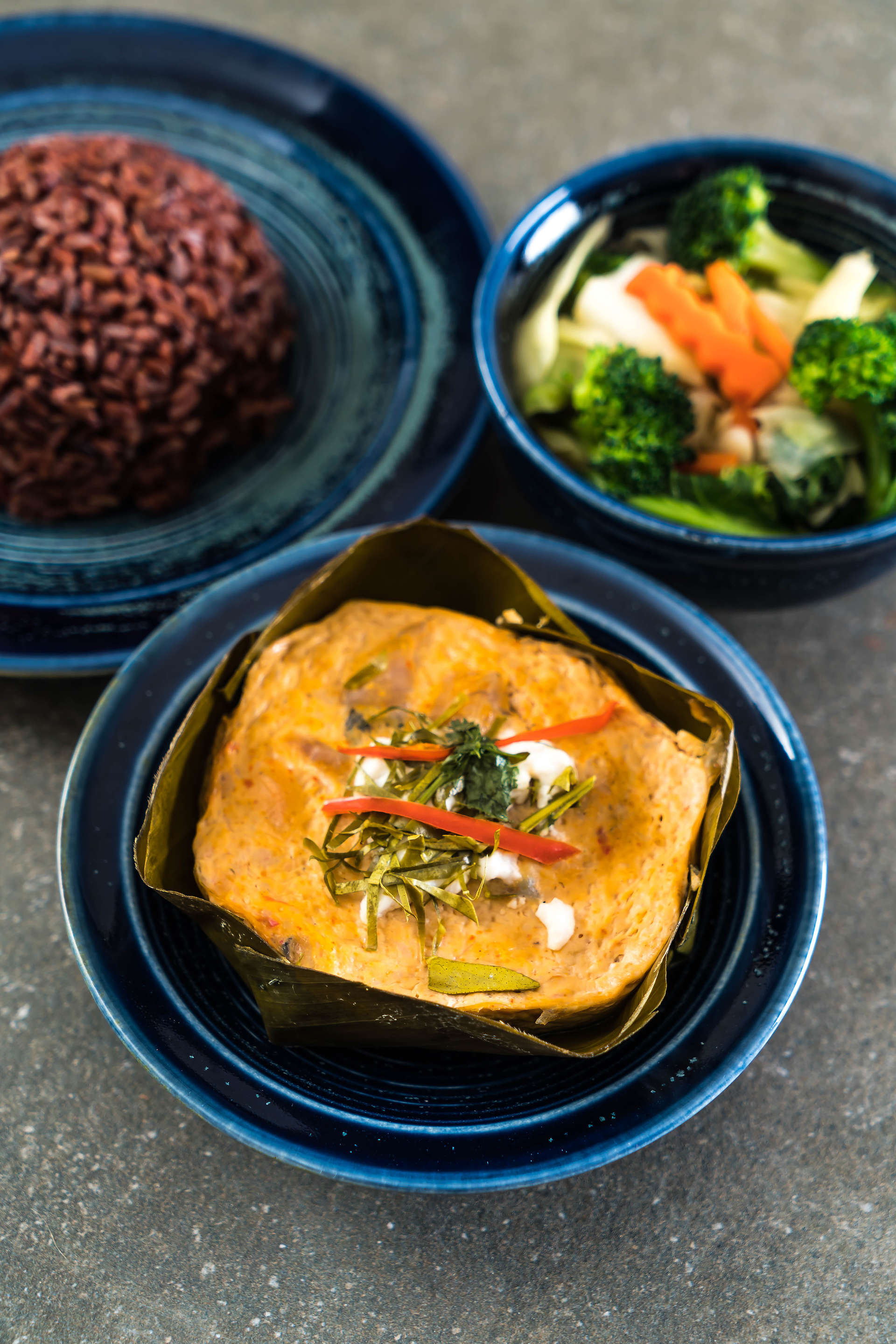 Overhead flat-lay of all ingredients for Cambodian Amok Trey laid out on a kitchen surface.