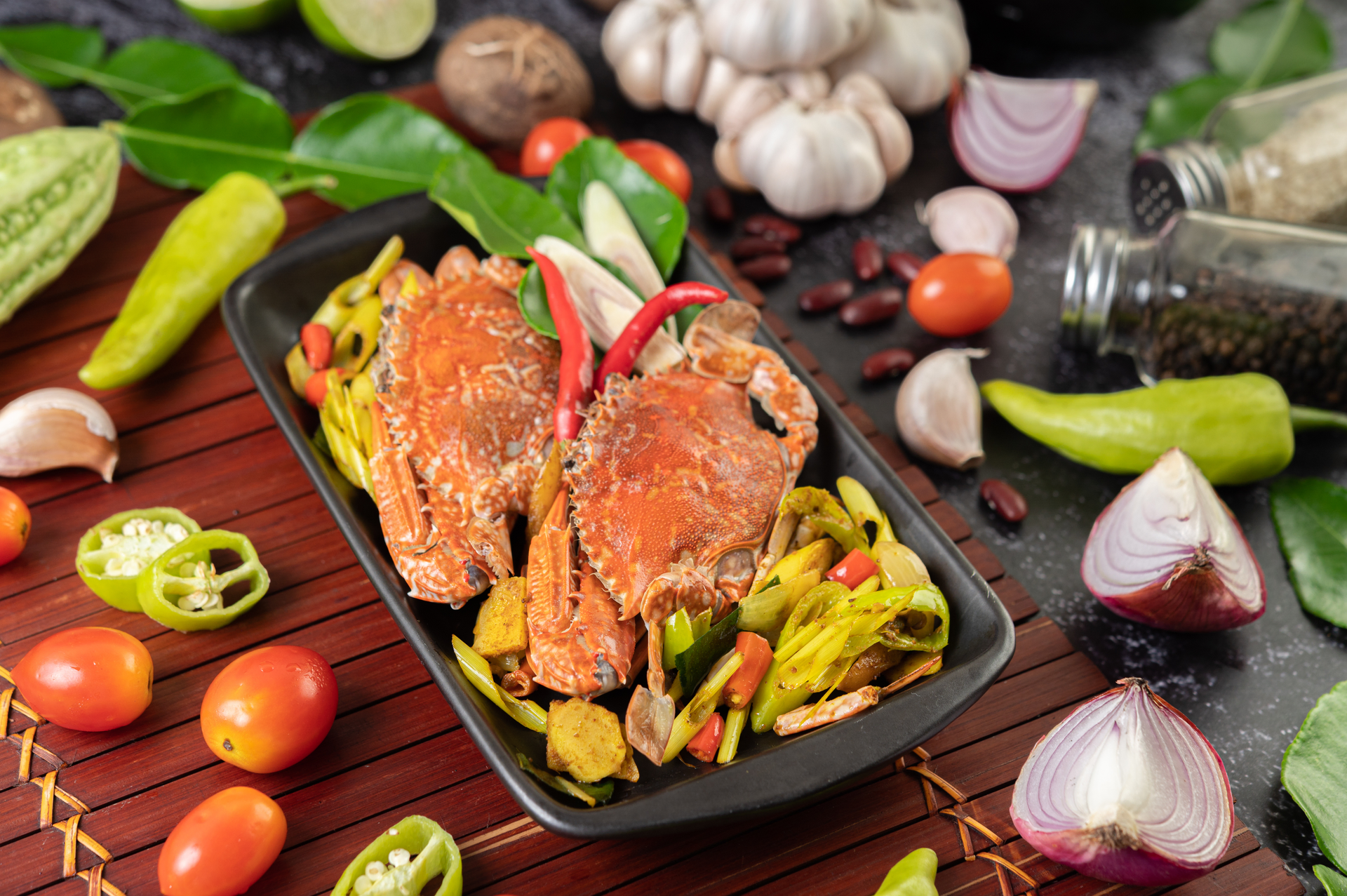Overhead flat-lay of all ingredients for Cambodian Peppercorn Crab Stir-Fry with Fragrant Herbs laid out on a kitchen surface.