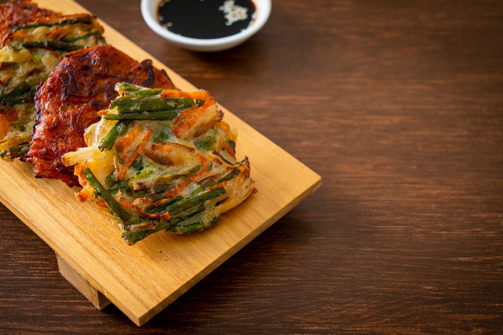 Caramelized Korean Jeon with Green Onion and Garlic Chives — Appetizer served and photographed from above