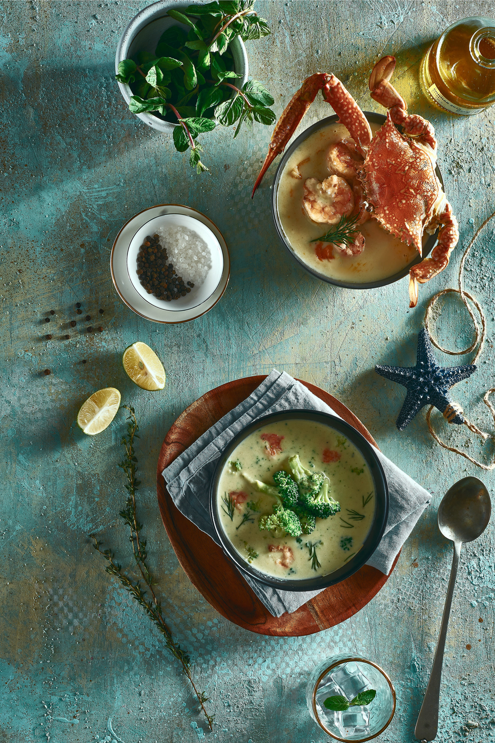 Overhead flat-lay of all ingredients for Caribbean Callaloo Soup with Crab and Coconut Milk laid out on a kitchen surface.