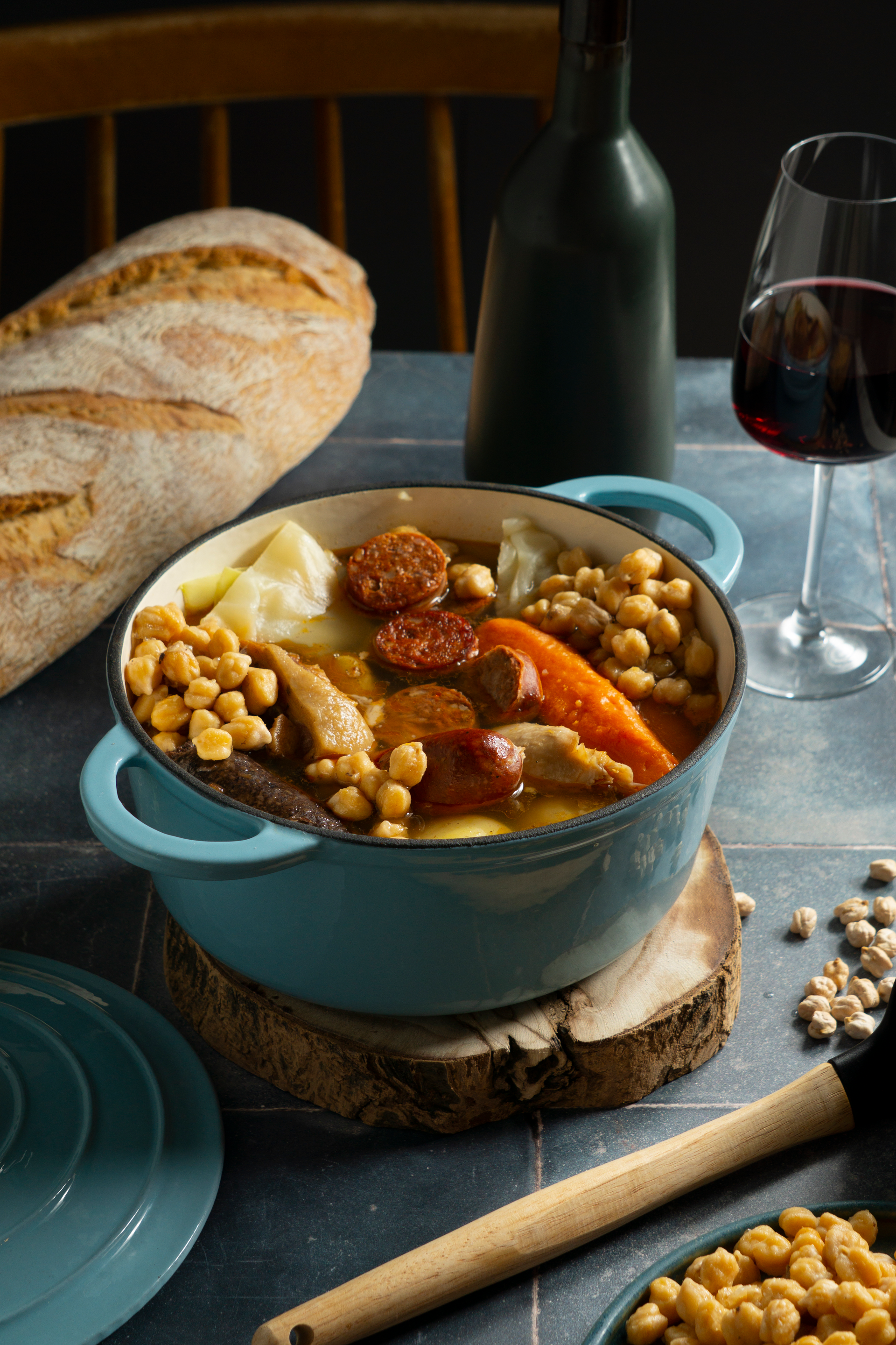 Overhead flat-lay of all ingredients for Catalan Escudella i Carn d'Olla with Winter Vegetables laid out on a kitchen surface.