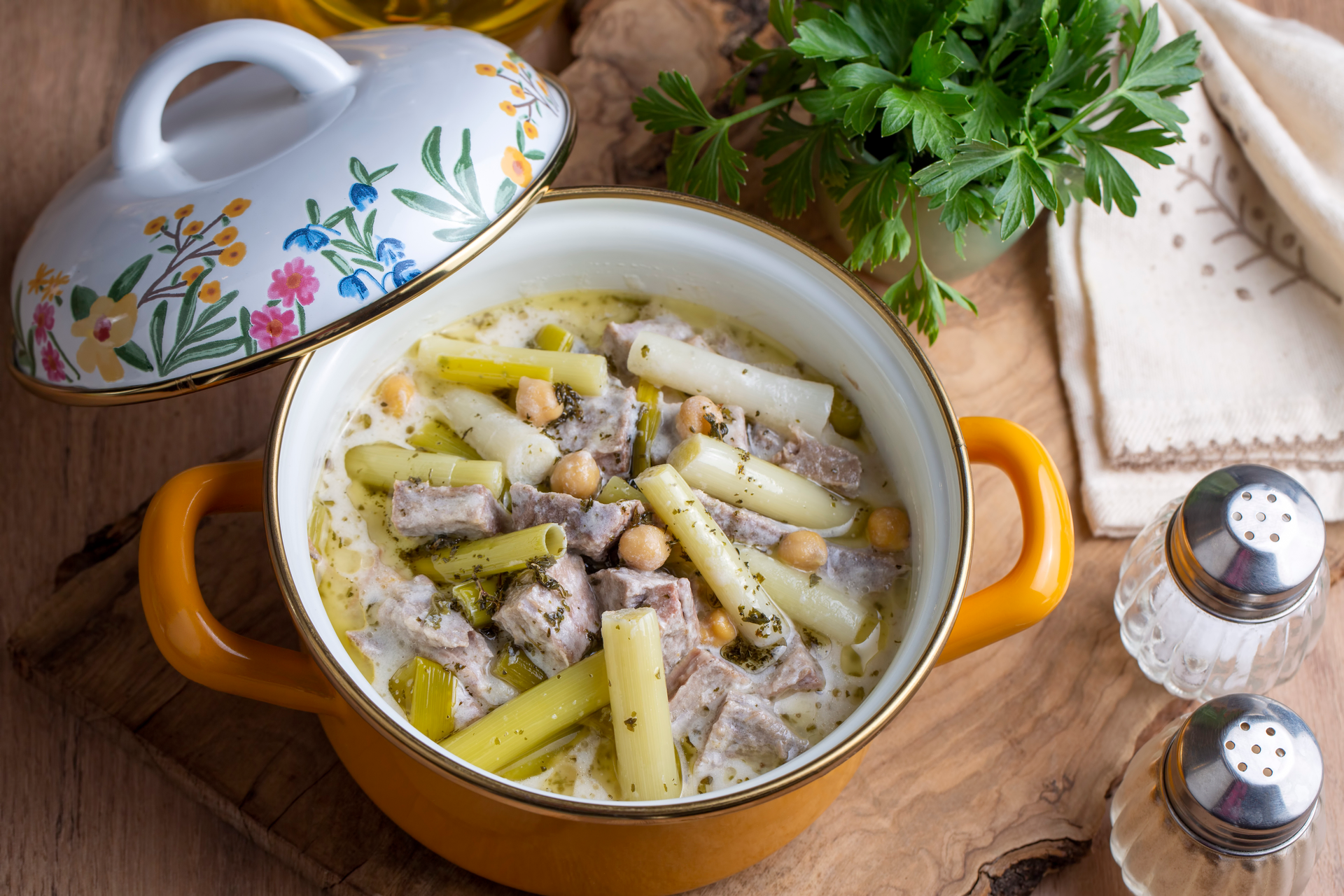 Overhead flat-lay of all ingredients for Catalonian Escudella with Pork and Vegetables laid out on a kitchen surface.