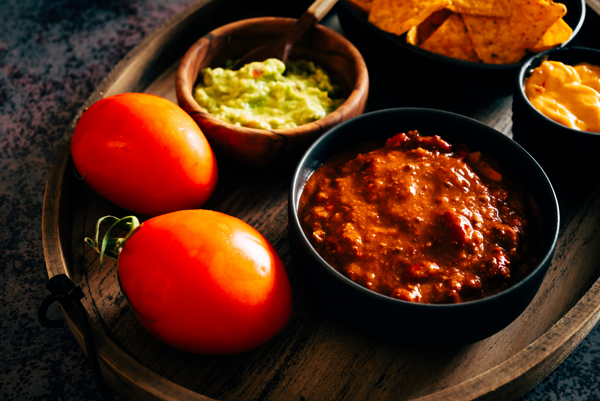 Overhead flat-lay of all ingredients for Chilean Pebre Sauce with Tomato and Coriander laid out on a kitchen surface.