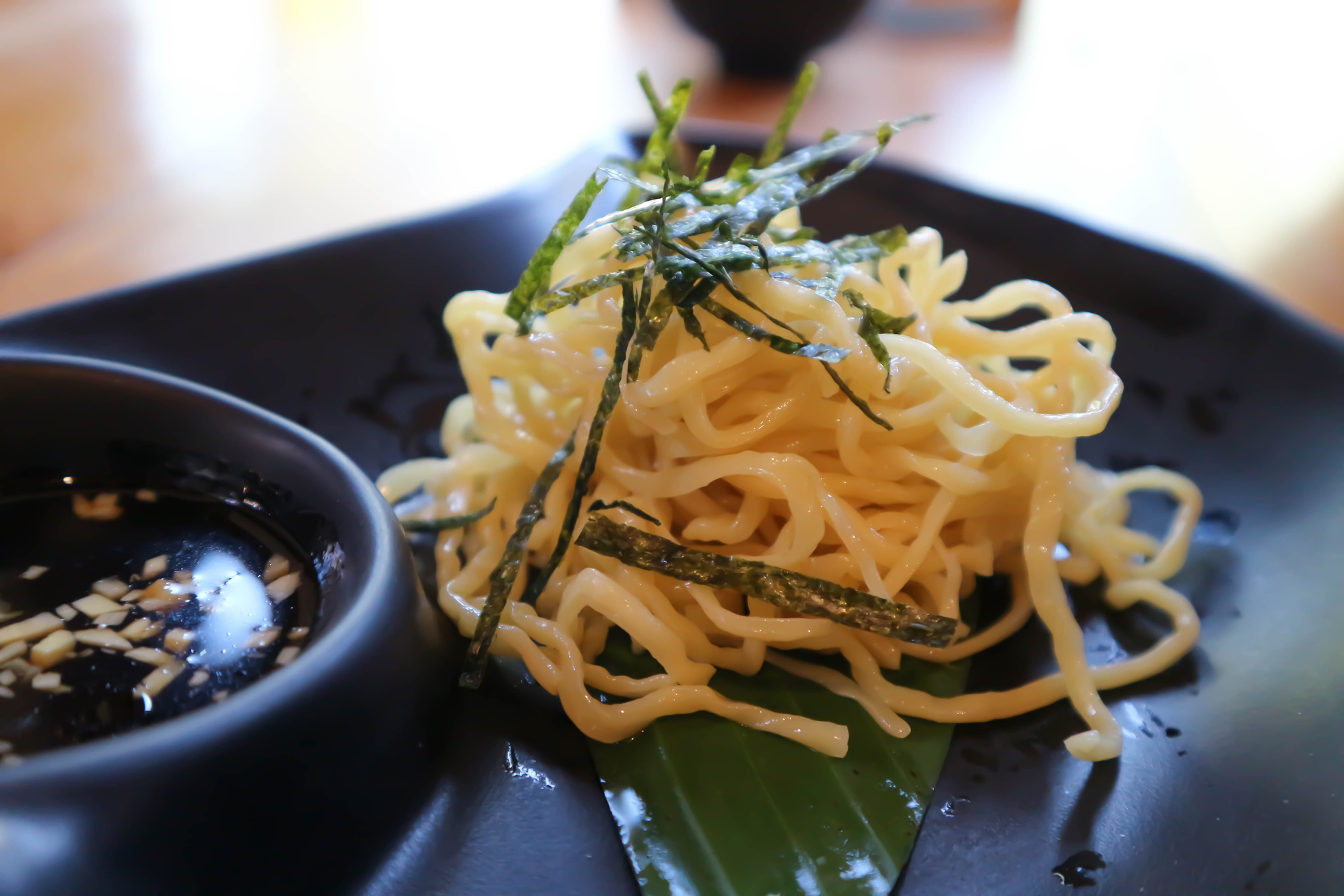 Overhead flat-lay of all ingredients for Citrus-Ginger Japanese Udon Noodles with Scallion and Shiso laid out on a kitchen surface.