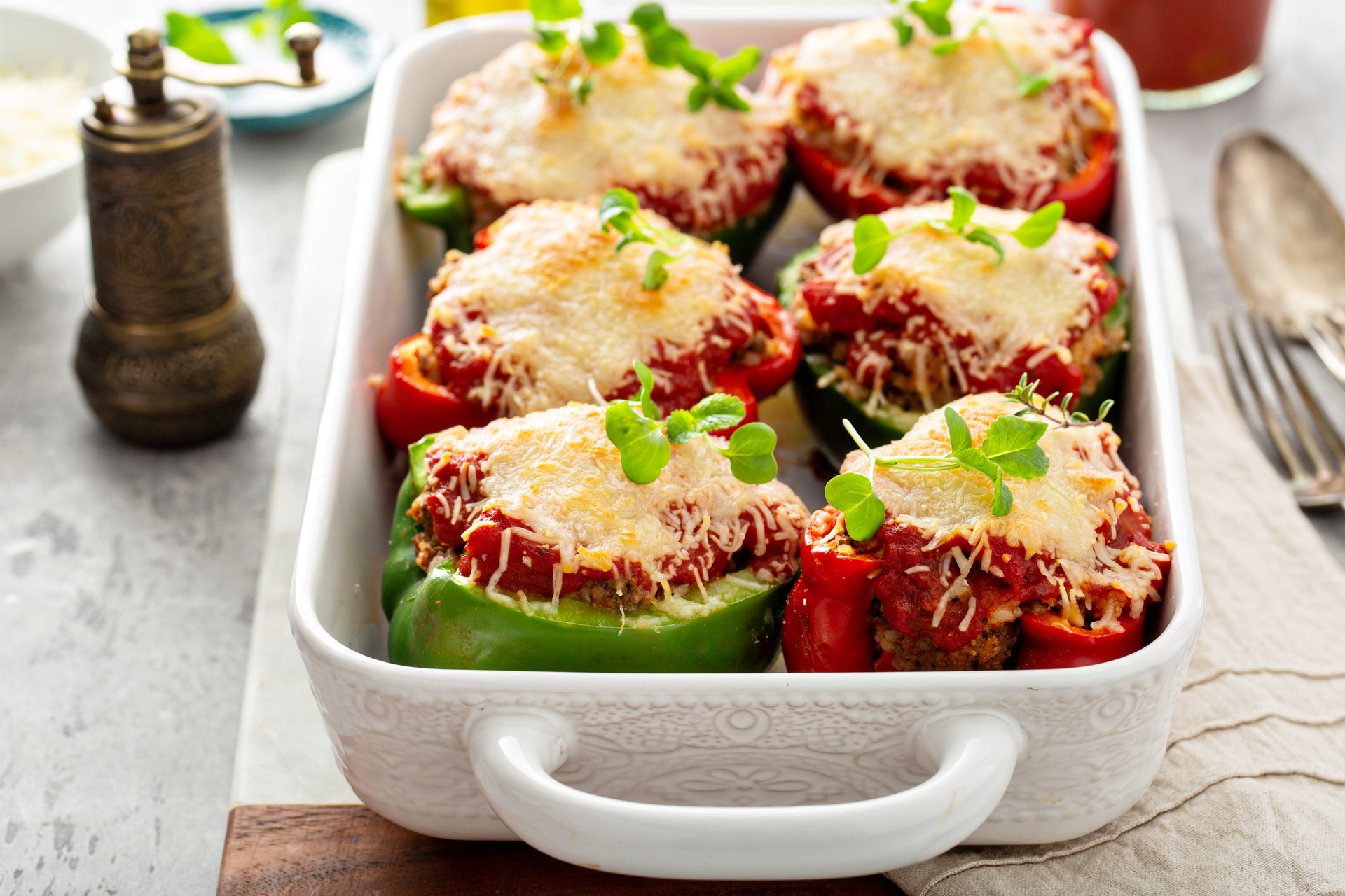 Overhead flat-lay of all ingredients for Citrusy Greek Stuffed Peppers with Ouzo Béchamel laid out on a kitchen surface.