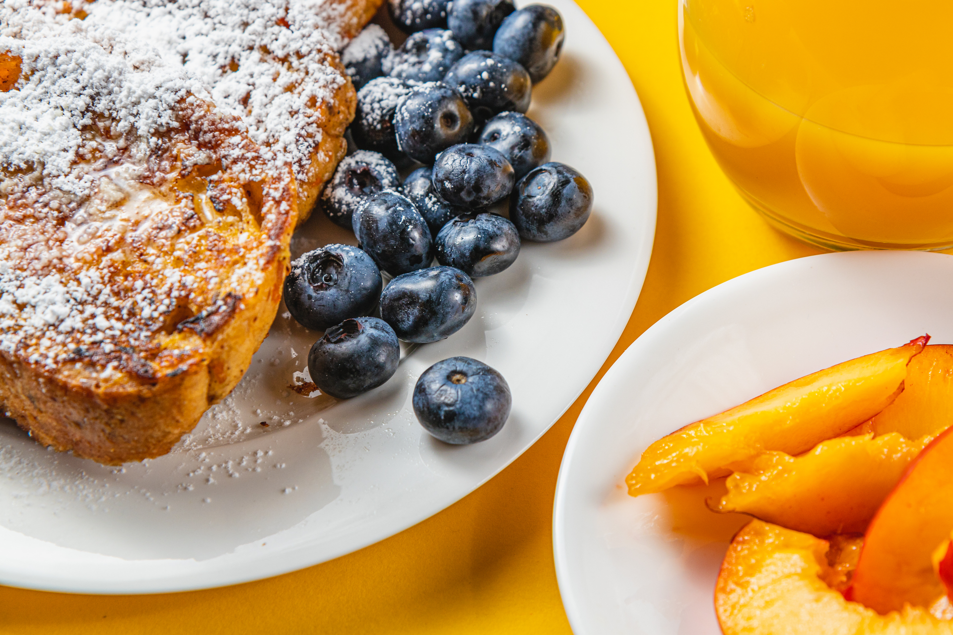 Overhead flat-lay of all ingredients for Citrusy Italian Lemon Ricotta Pancakes with Blueberry Compote laid out on a kitchen surface.