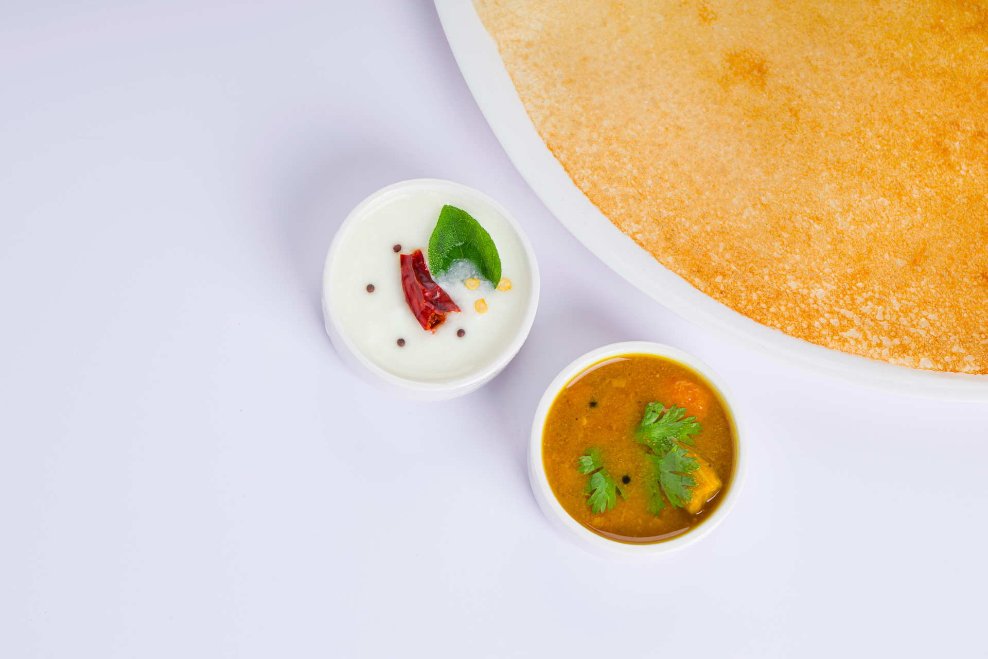 Overhead flat-lay of all ingredients for Classic Indian Dosa with Coconut Chutney and Sambar laid out on a kitchen surface.