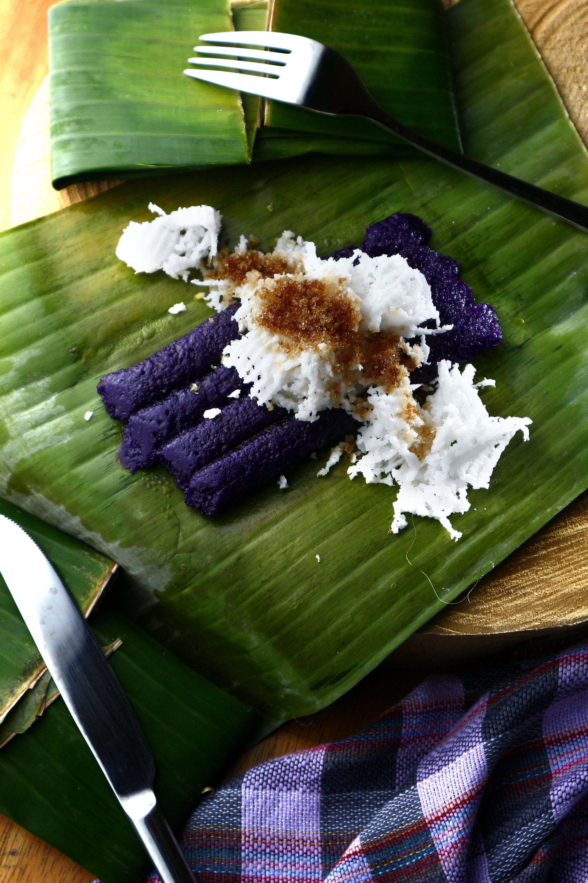 Overhead flat-lay of all ingredients for Coconut-Laden Samoan Palusami with Taro Leaves and Citrus laid out on a kitchen surface.