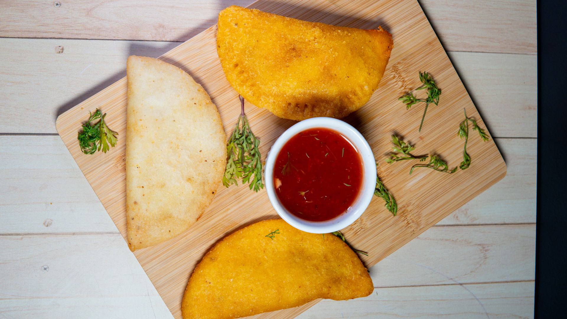 Overhead flat-lay of all ingredients for Colombian Chicken Empanadas with Aji Picante Dipping Sauce laid out on a kitchen surface.