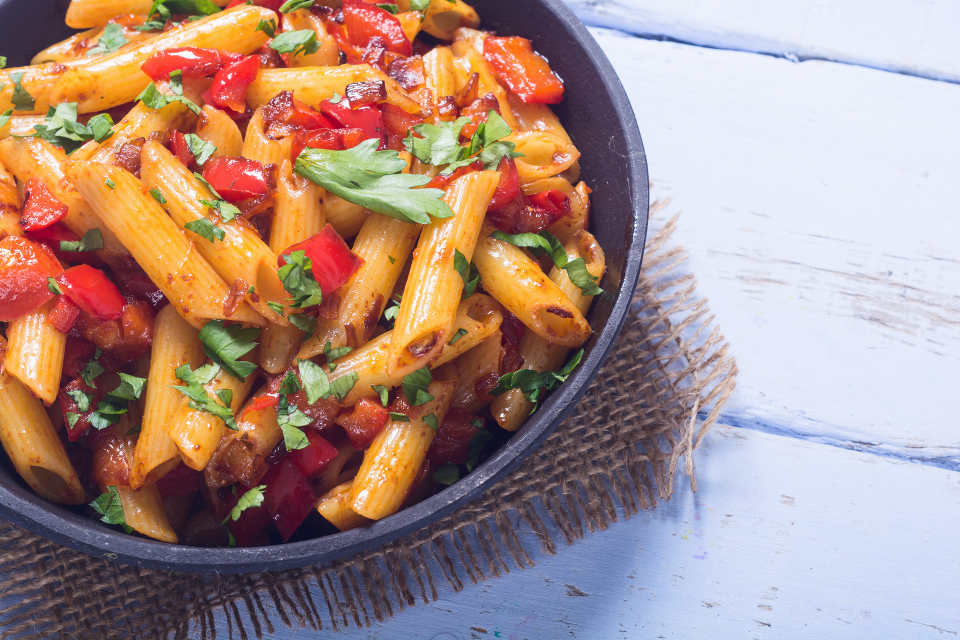 Overhead flat-lay of all ingredients for Creamy Argentine Chimichurri Pasta with Roasted Red Peppers laid out on a kitchen surface.