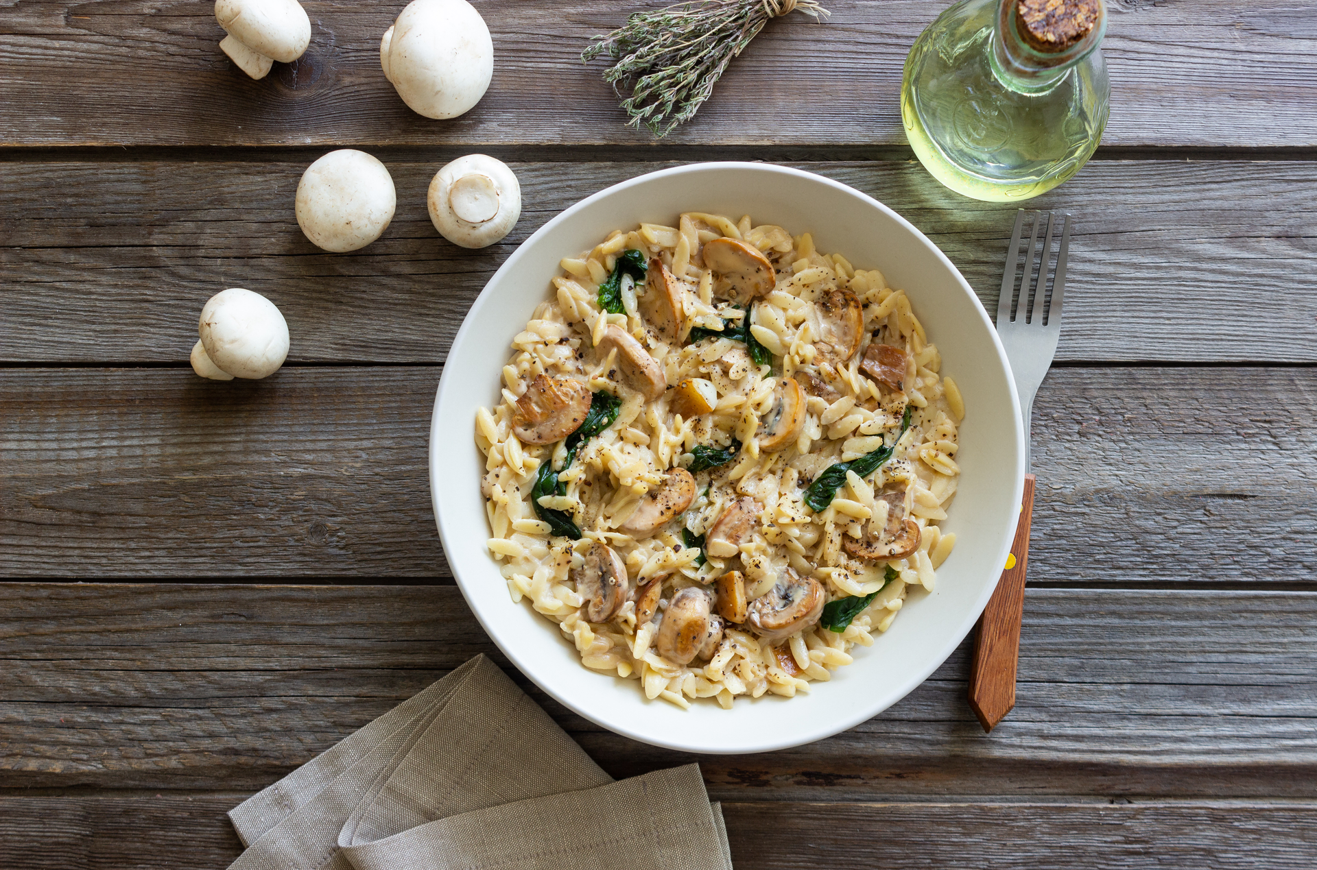 Overhead flat-lay of all ingredients for Creamy Bavarian Mushroom Spaetzle with Smoked Cheese and Thyme laid out on a kitchen surface.