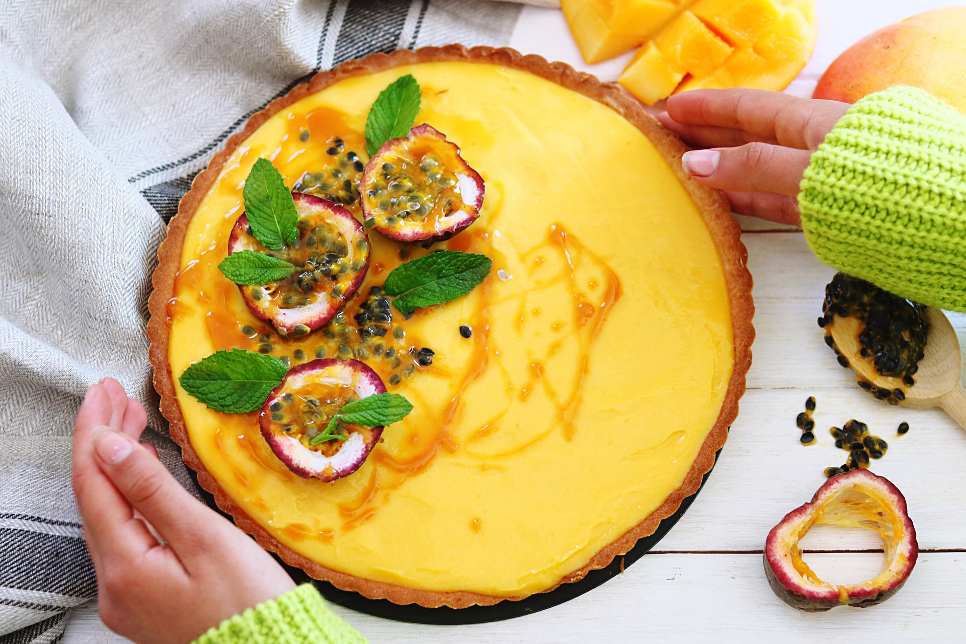 Overhead flat-lay of all ingredients for Creamy Brazilian Cassava Cheesecake with Passionfruit Sauce laid out on a kitchen surface.