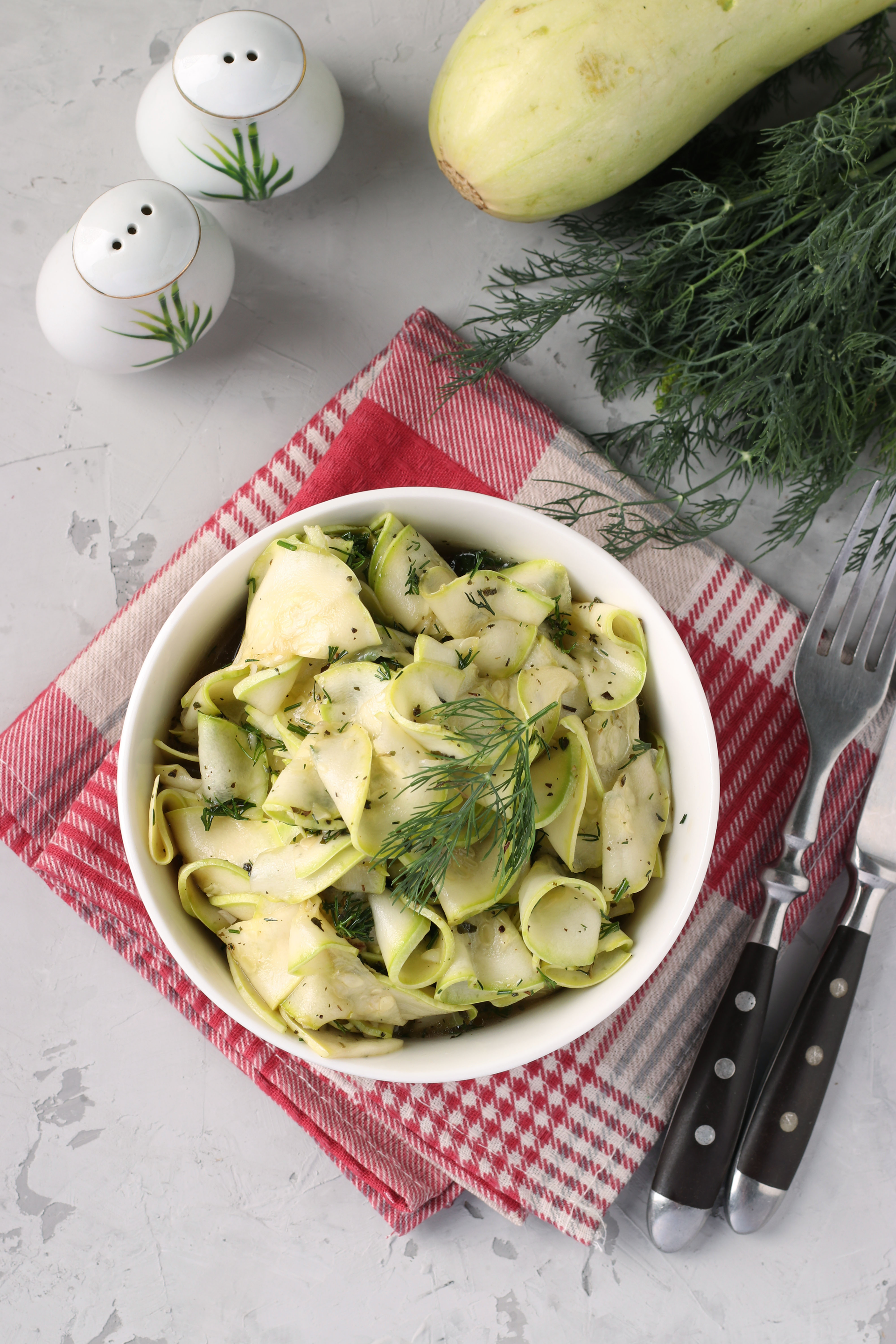 Overhead flat-lay of all ingredients for Creamy Cypriot Tzatziki Pasta with Cucumber and Dill laid out on a kitchen surface.