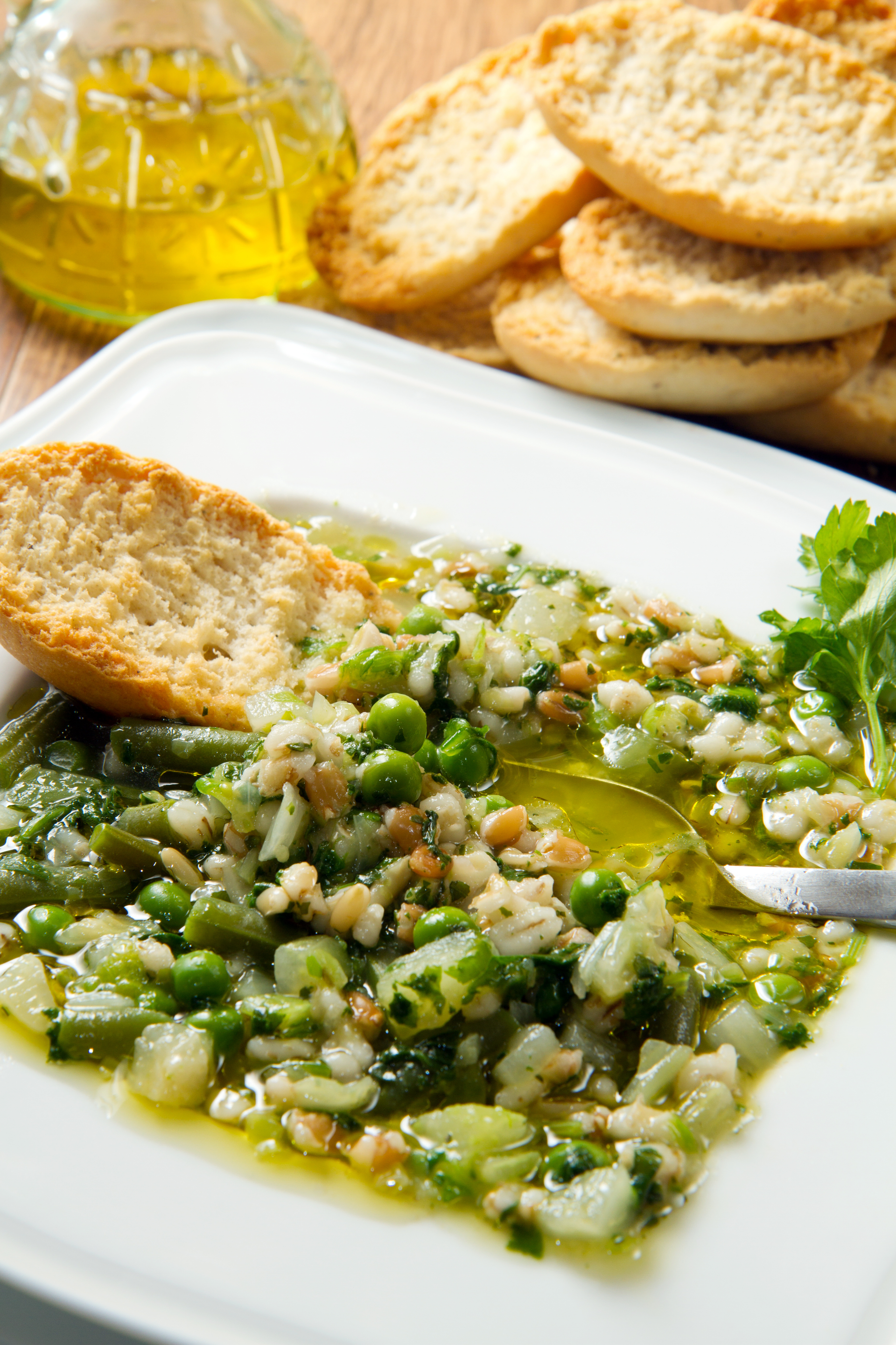 Overhead flat-lay of all ingredients for Creamy Egyptian Besara with Fava Beans and Olive Oil laid out on a kitchen surface.