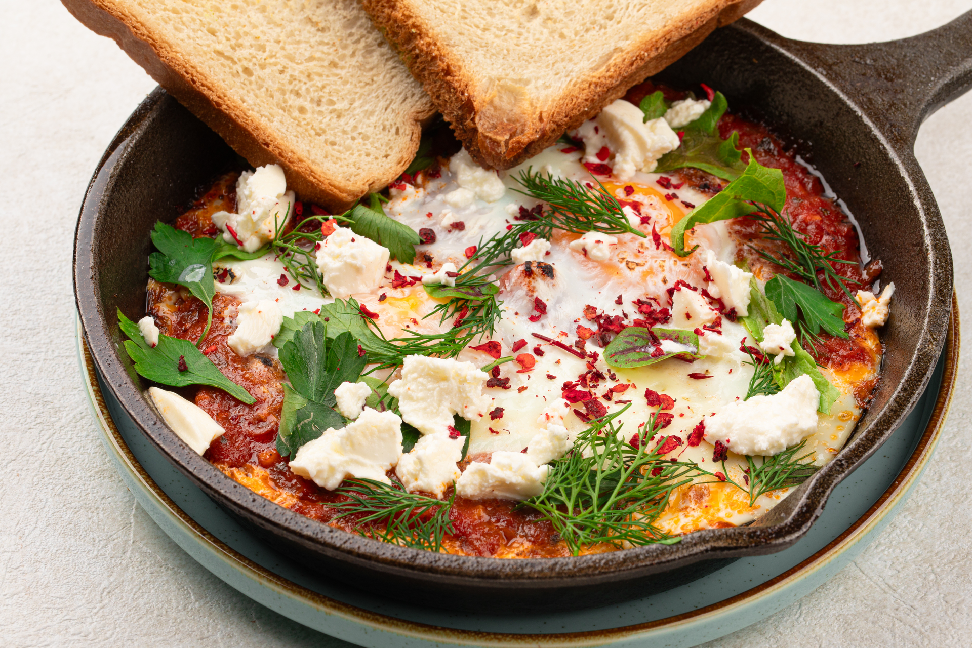 Overhead flat-lay of all ingredients for Creamy Egyptian Feta and Tomato Shakshuka with Spiced Lamb laid out on a kitchen surface.