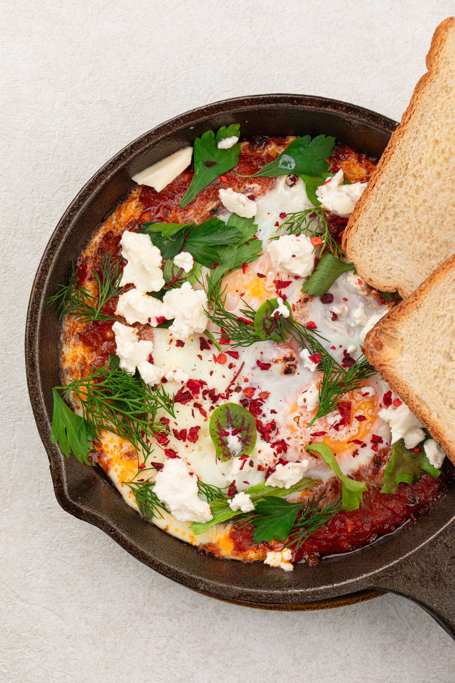 Creamy Egyptian Feta and Tomato Shakshuka with Spiced Lamb — Main Course served and photographed from above