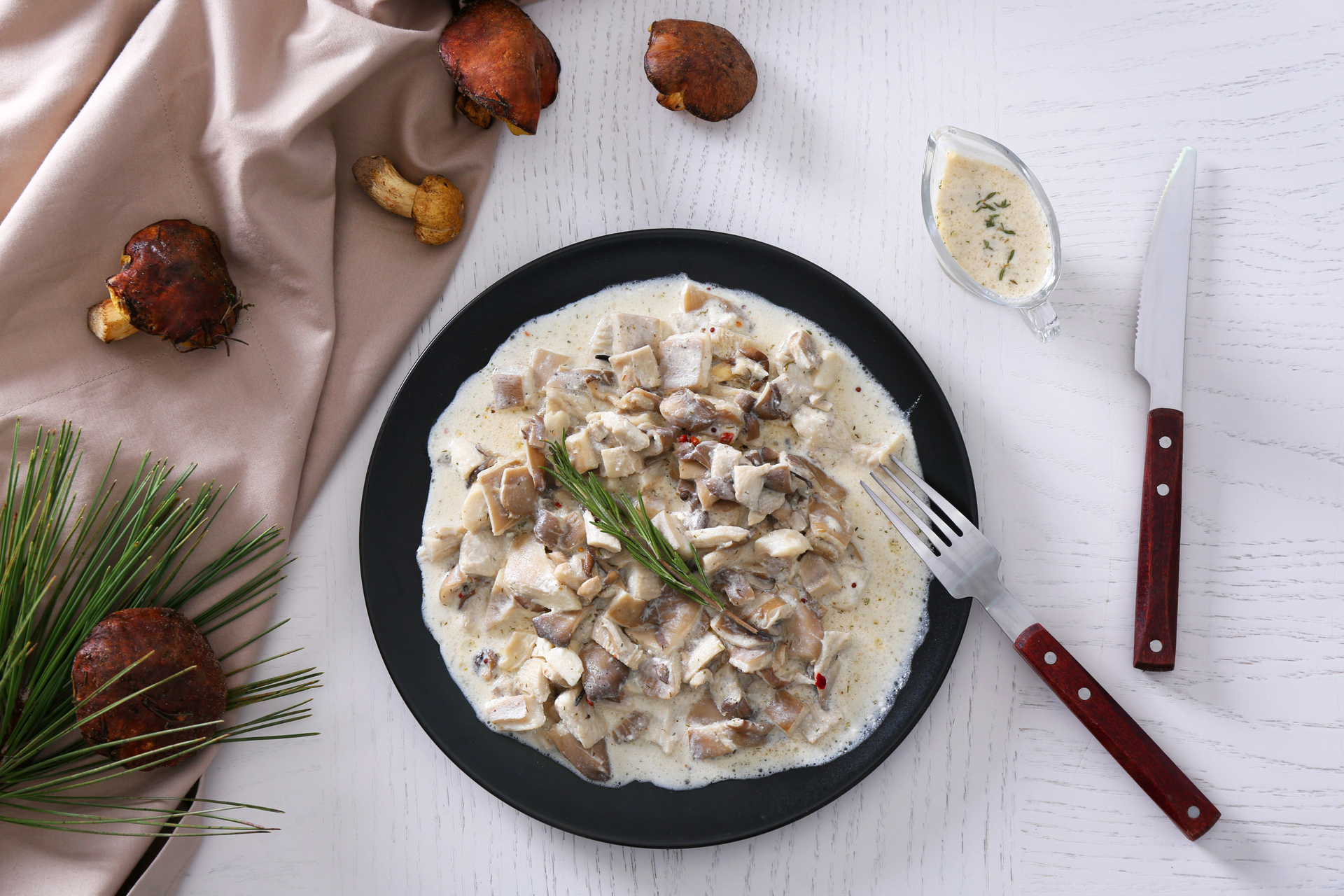 Overhead flat-lay of all ingredients for Creamy French Blanquette de Veau with Mushrooms and Pearl Onions laid out on a kitchen surface.