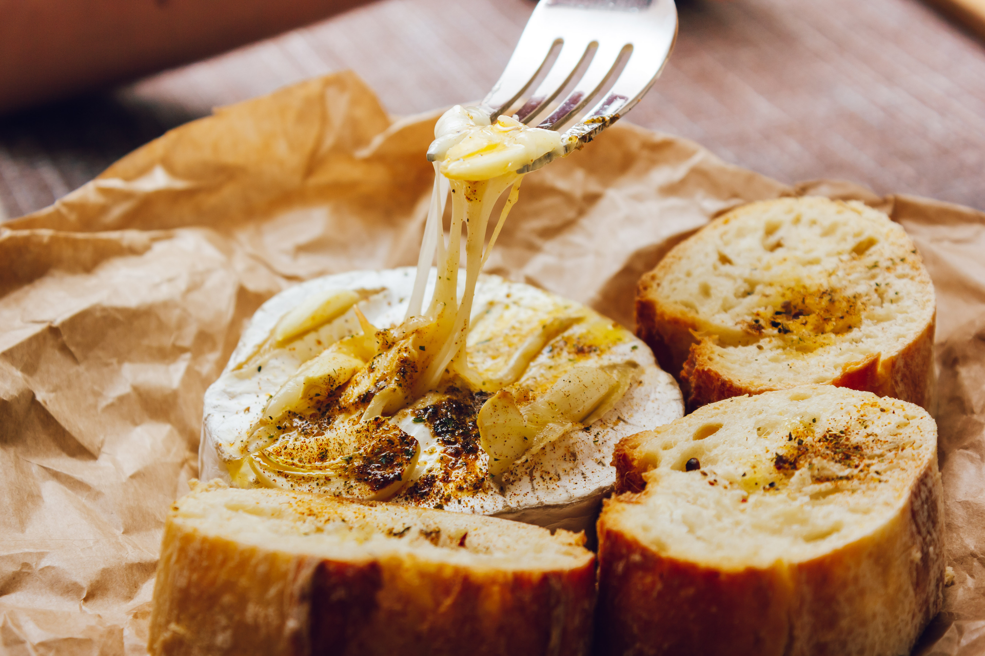Overhead flat-lay of all ingredients for Creamy French Époisses Fondue with Crusty Baguette laid out on a kitchen surface.