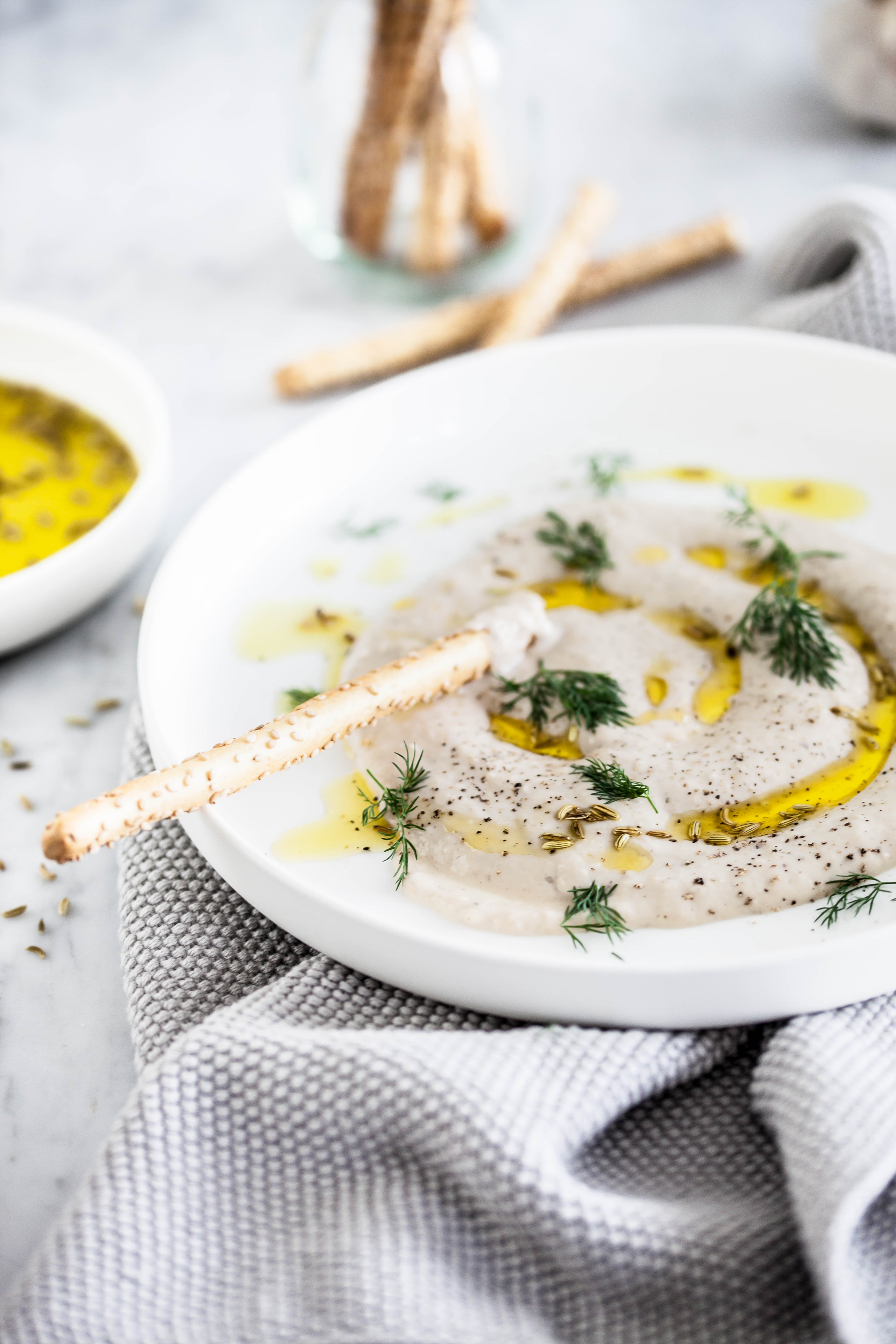 Overhead flat-lay of all ingredients for Creamy Greek Saganaki with Lemon and Ouzo laid out on a kitchen surface.