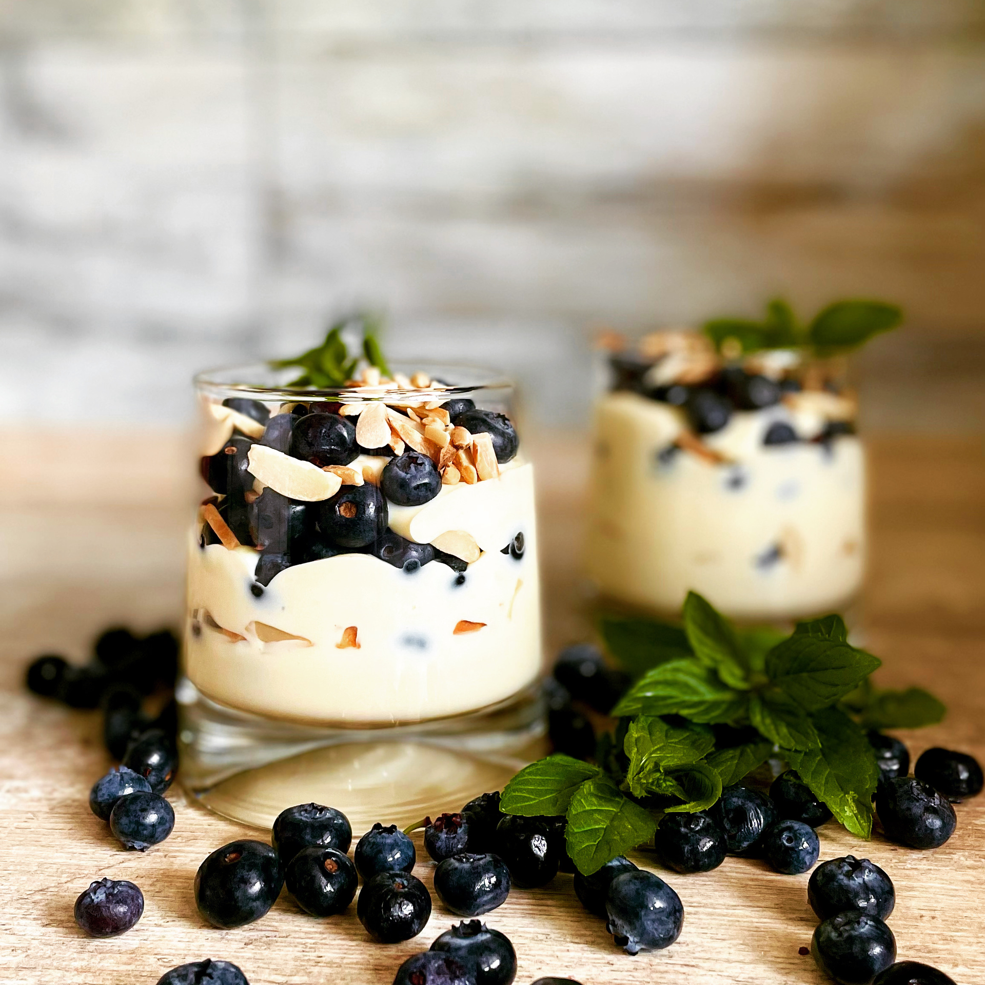 Overhead flat-lay of all ingredients for Creamy Icelandic Skyr Parfait with Blueberries and Honey laid out on a kitchen surface.